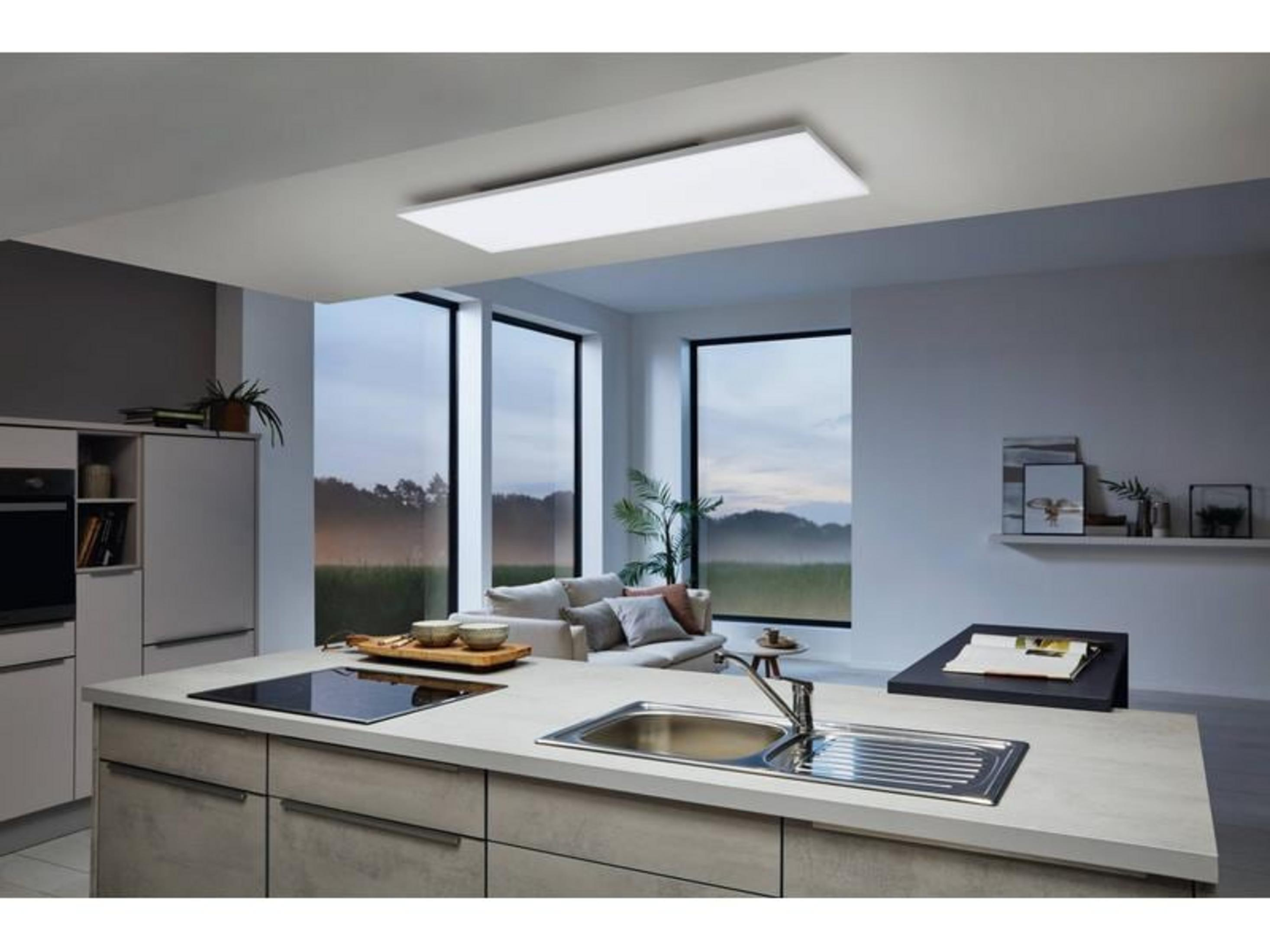 Cocina moderna con isla, fregadero, vista a sala y paisaje.