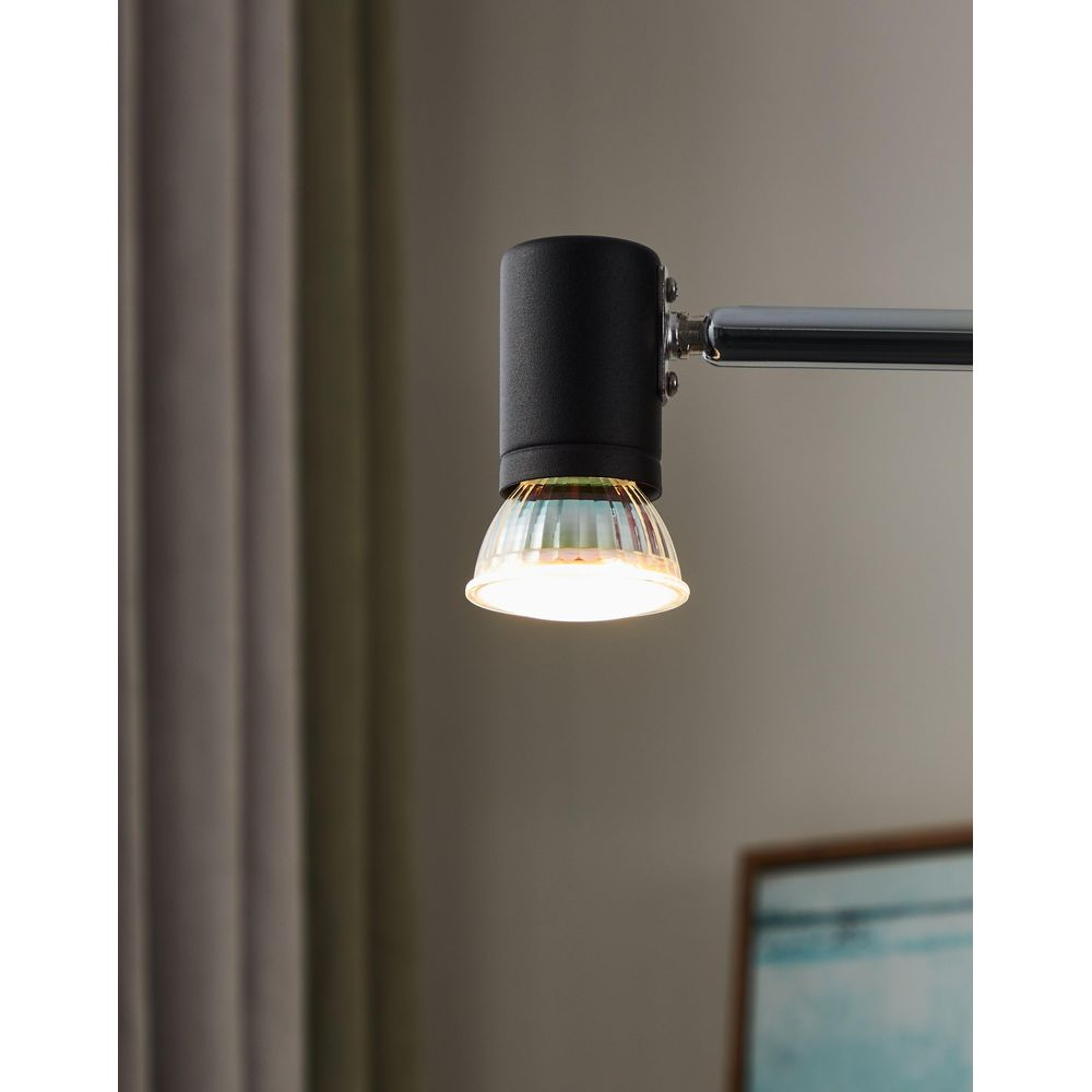 Une tête de lampe noire avec verre et ampoule s'illumine.