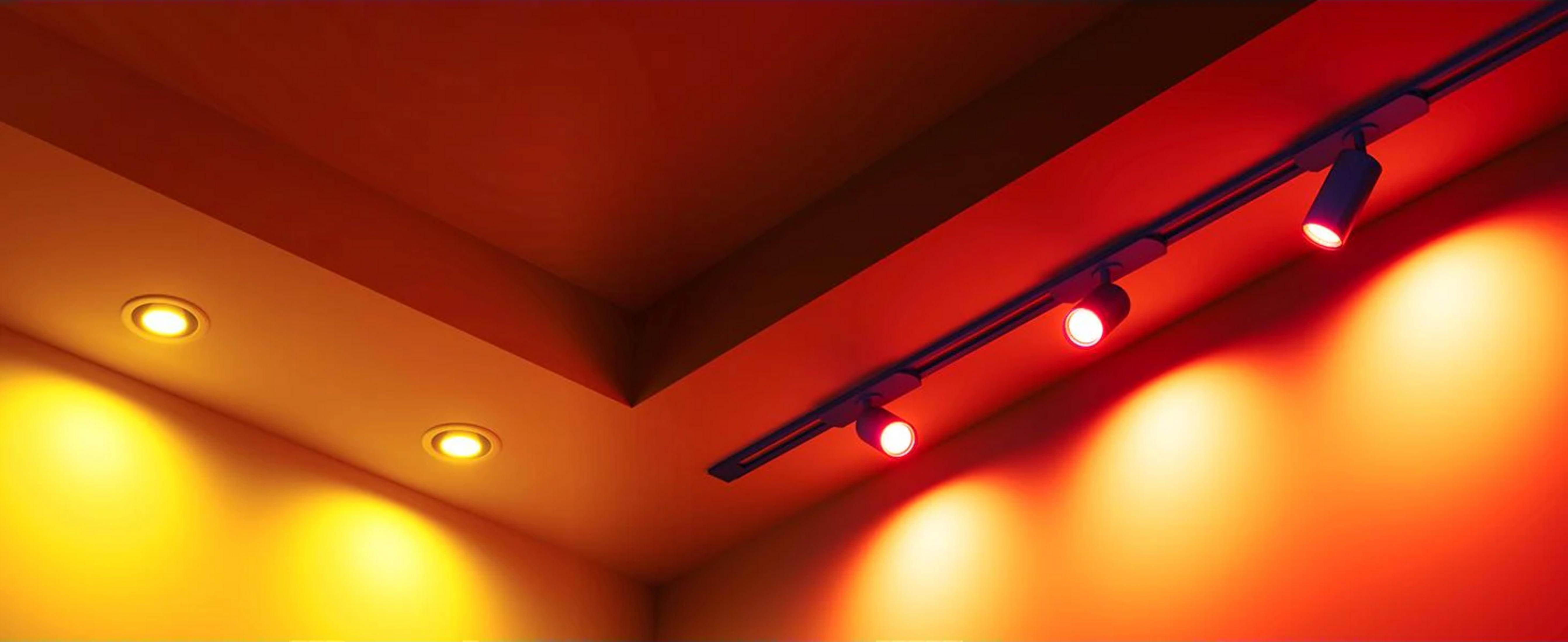 Una stanza angolare con luci a soffitto, illuminata in rosso e giallo.