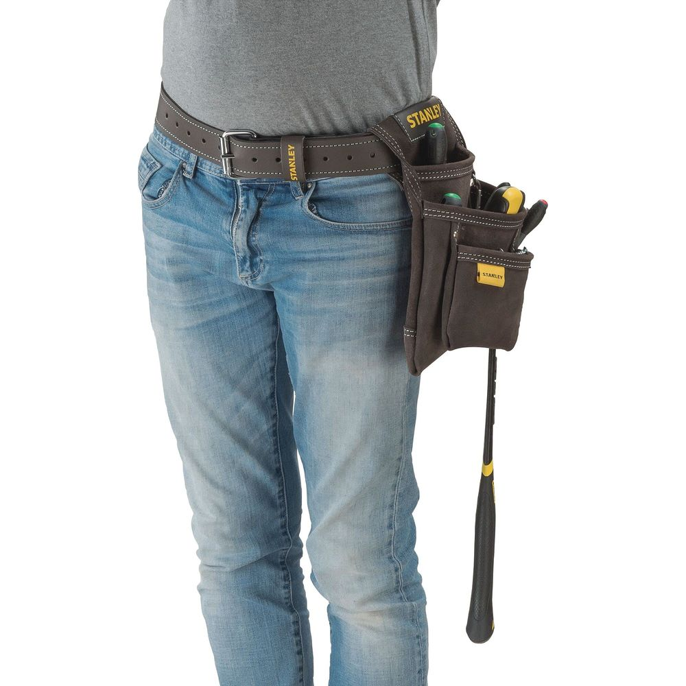 Una persona viste camiseta gris, jeans azules y un cinturón de herramientas marrón oscuro con bolsillos.