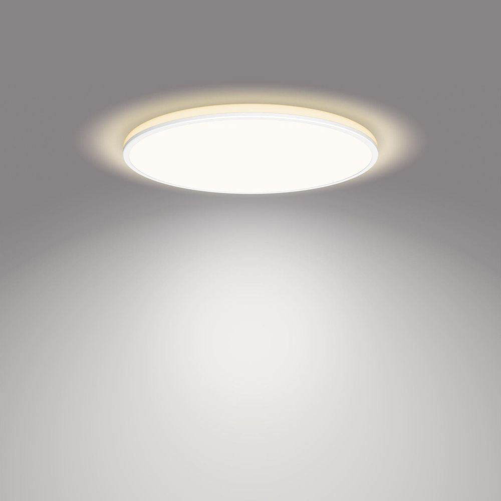 Una lampada da soffitto rotonda con un raggio di luce brillante su sfondo grigio.