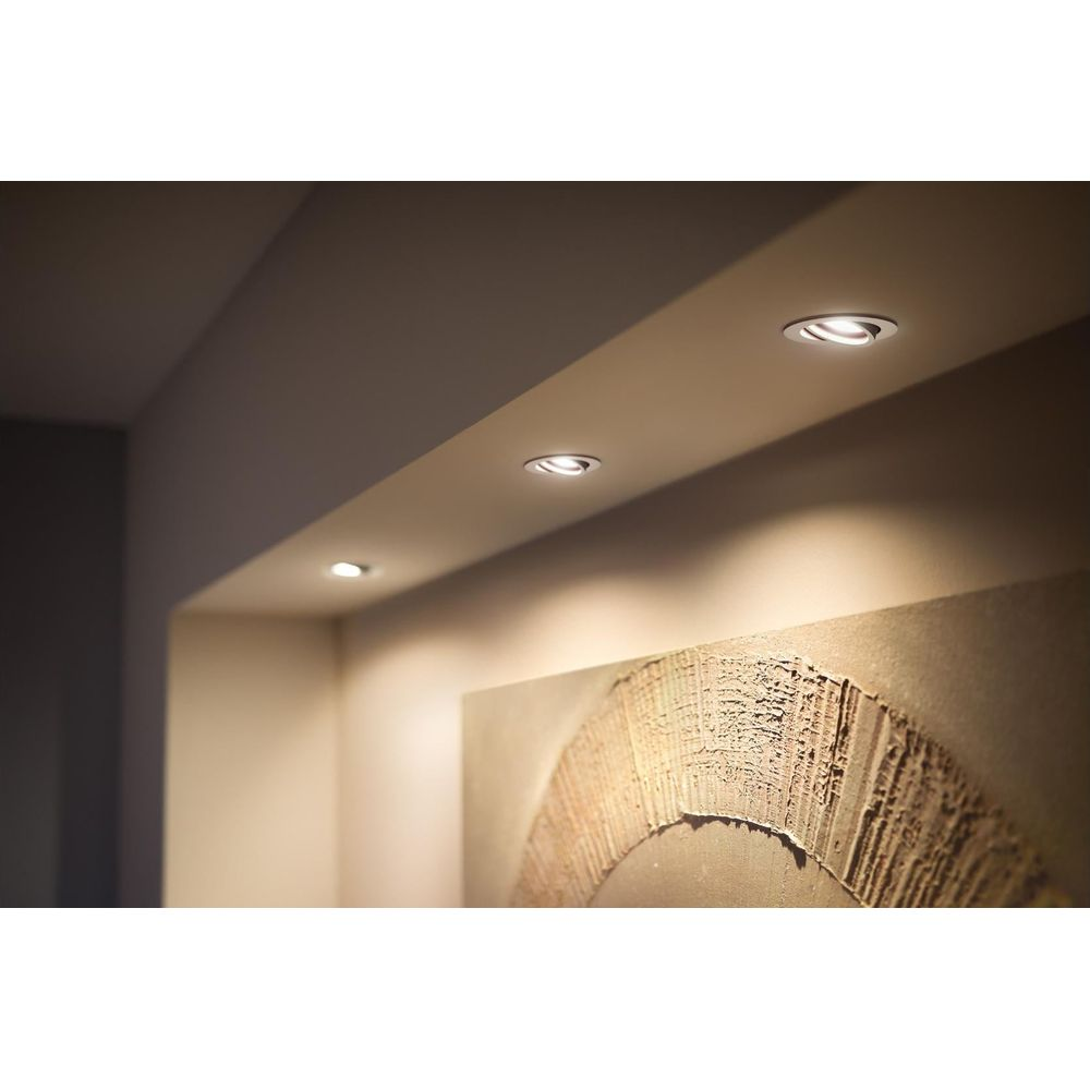 Oświetlenie wpuszczane oświetla ścianę z dziełem sztuki.