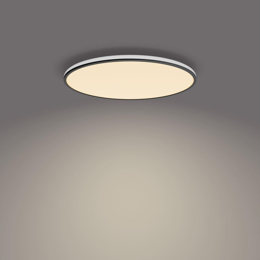 Una plafoniera rotonda e piatta con cornice bianca e centro illuminato.