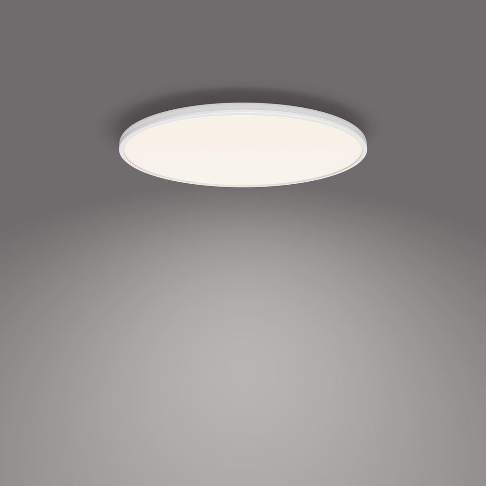 Un plafonnier LED blanc, circulaire et encastré est montré sur un fond gris.
