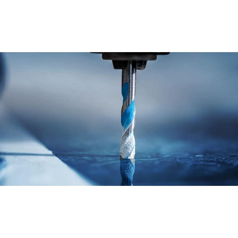 Niebieski wiertło spiralne wierci w niebieską powierzchnię.