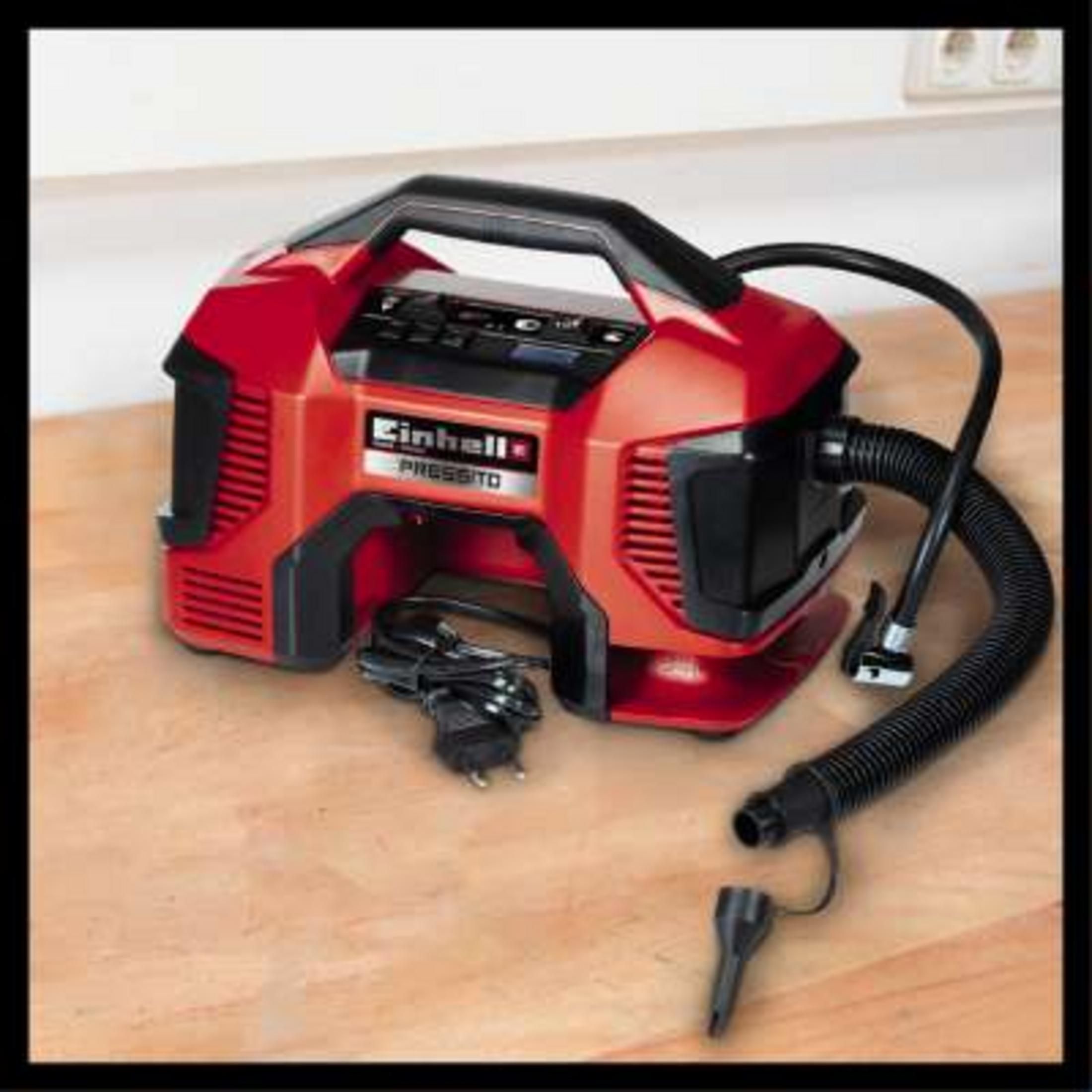 Ein roter, tragbarer Einhell Pressito Luftkompressor mit schwarzem Schlauch und Kabel.
