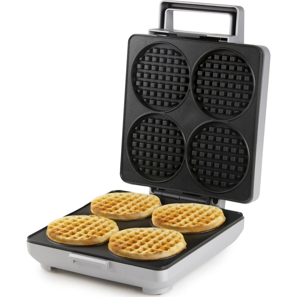 Ein offener Waffelautomat mit vier runden, goldbraunen Waffeln auf der unteren Platte.