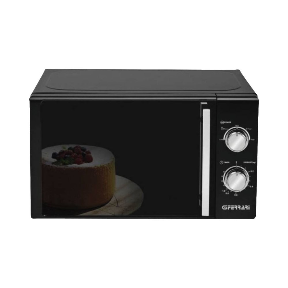 Forno a microonde nero con torta e frutti di bosco all'interno.