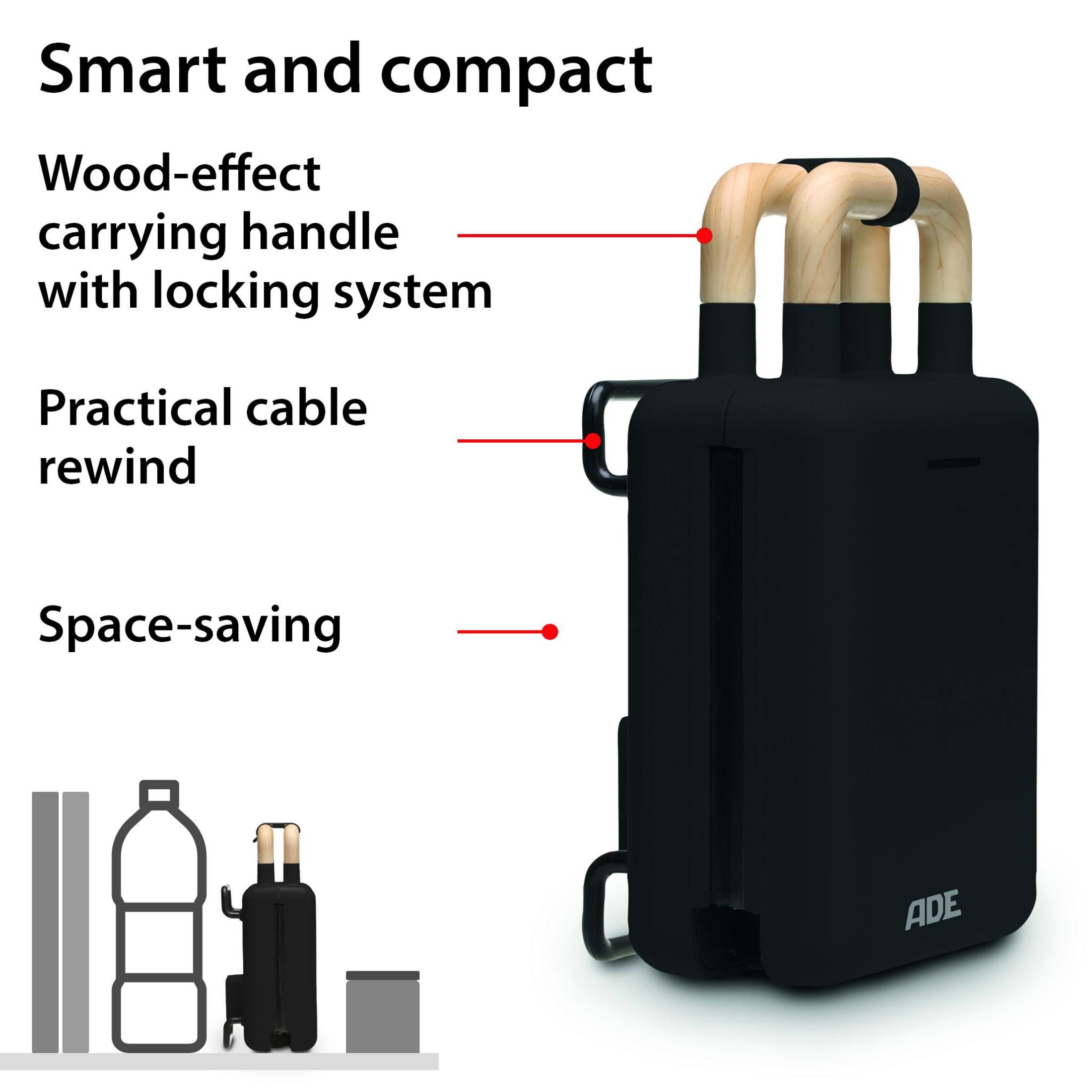 Czarne urządzenie z drewnianymi uchwytami, obok butelki wody i kosza.