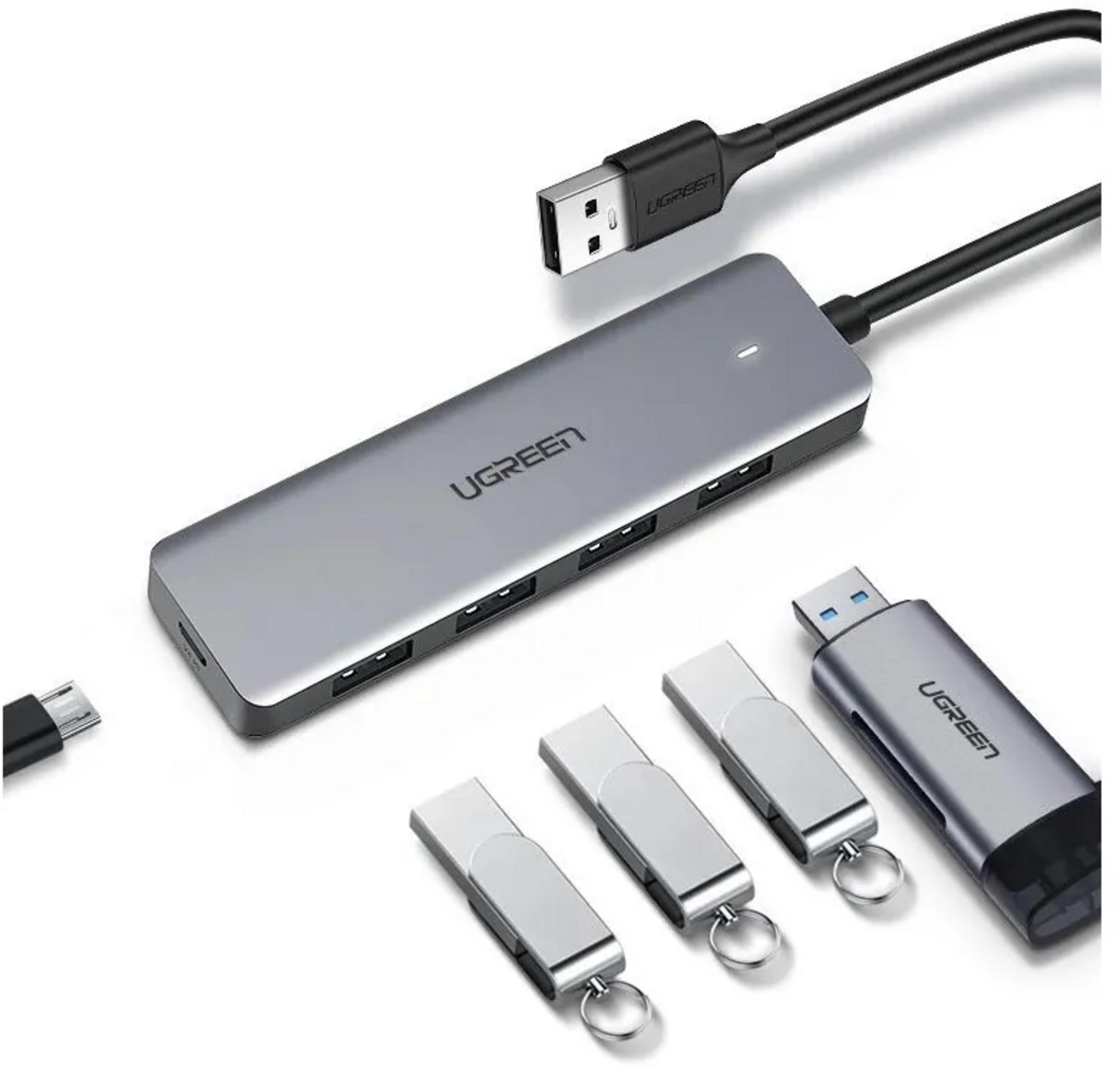Un hub USB grigio con cavi e tre chiavette USB nelle vicinanze.