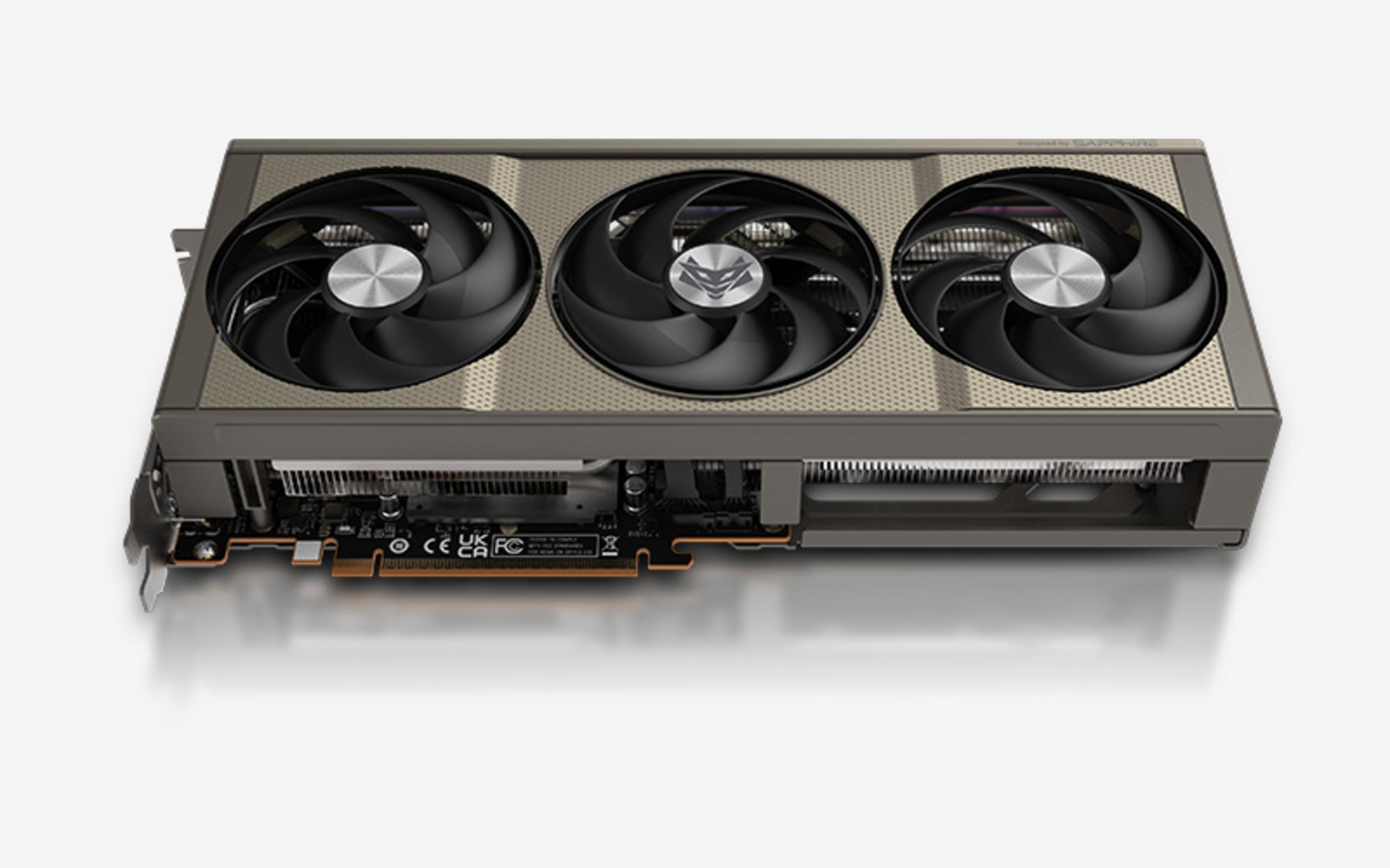Karta graficzna z trzema wentylatorami, srebrną obudową i widoczną płytką drukowaną.