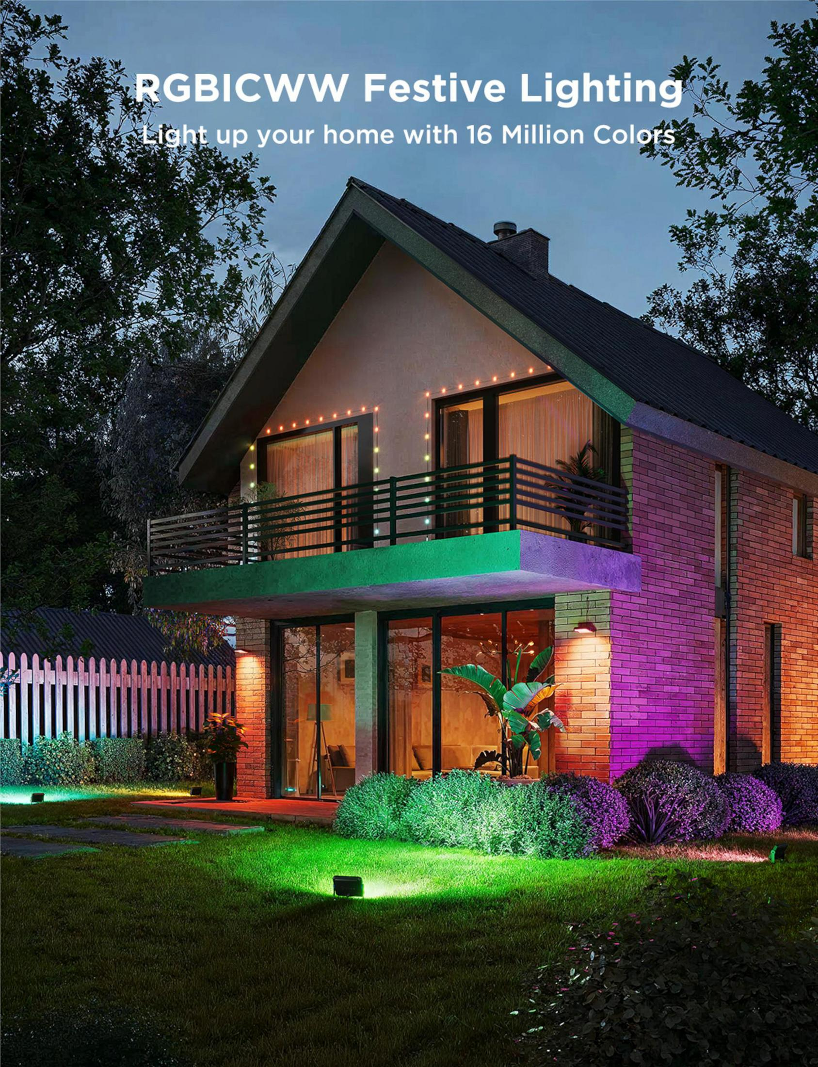 Une maison avec des guirlandes lumineuses colorées et des spots au sol illuminant le jardin.