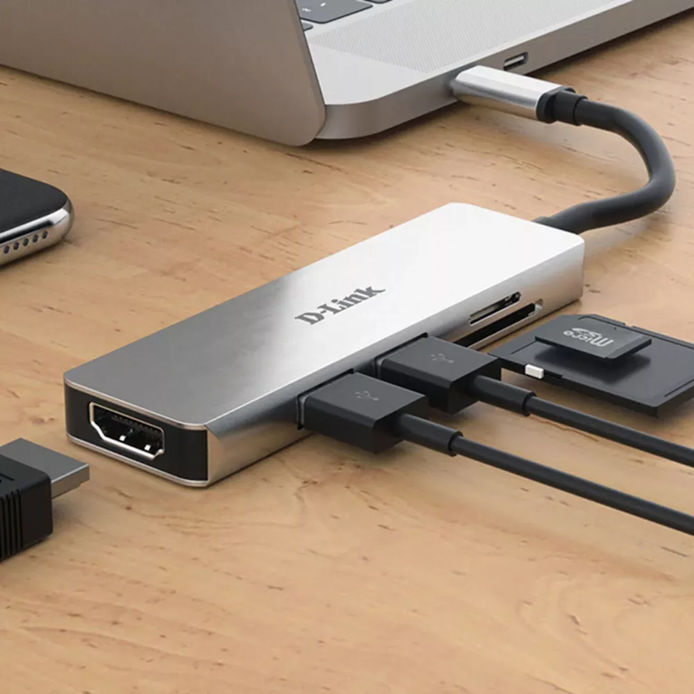 Srebrny hub USB-C D-Link z HDMI, kartą SD i portami USB podłączony do laptopa.