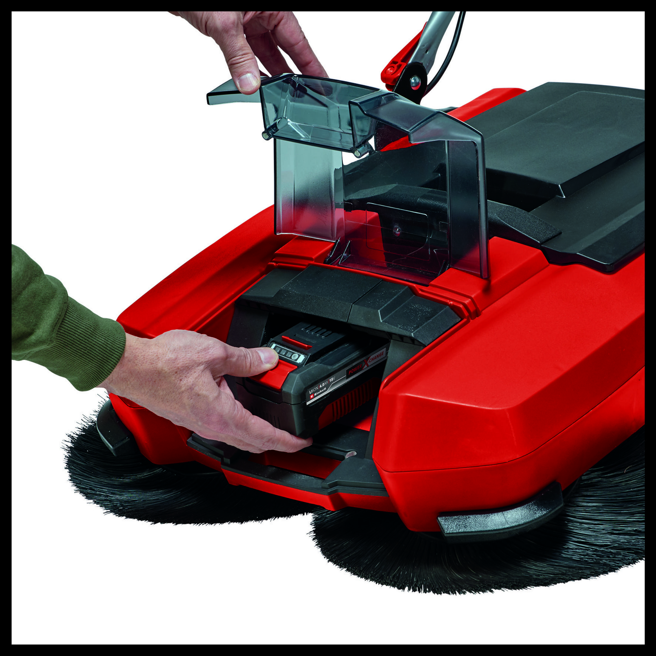 Un uomo inserisce una batteria in un dispositivo di pulizia rosso con spazzole.