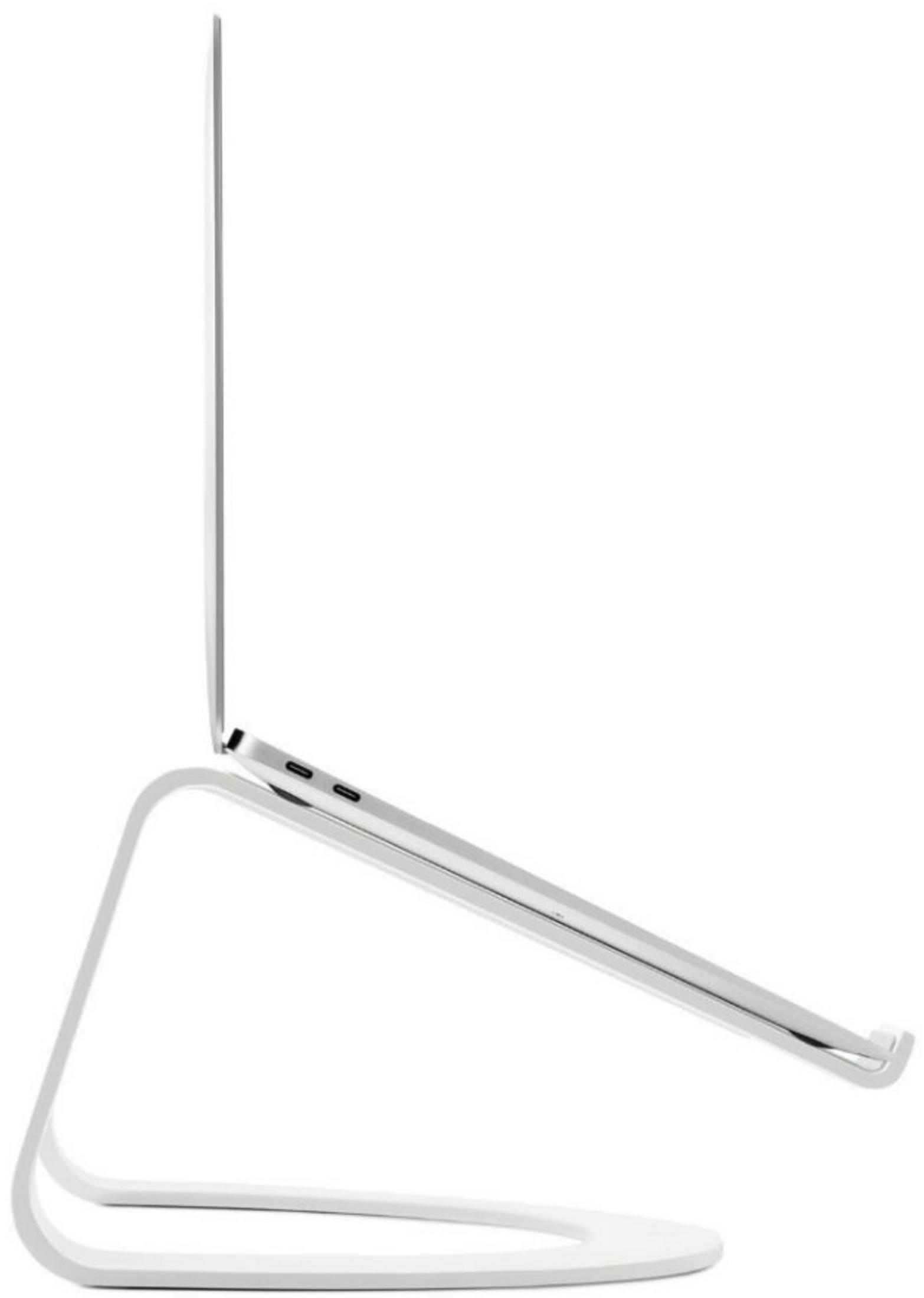 Srebrny laptop spoczywa na białej podstawie.