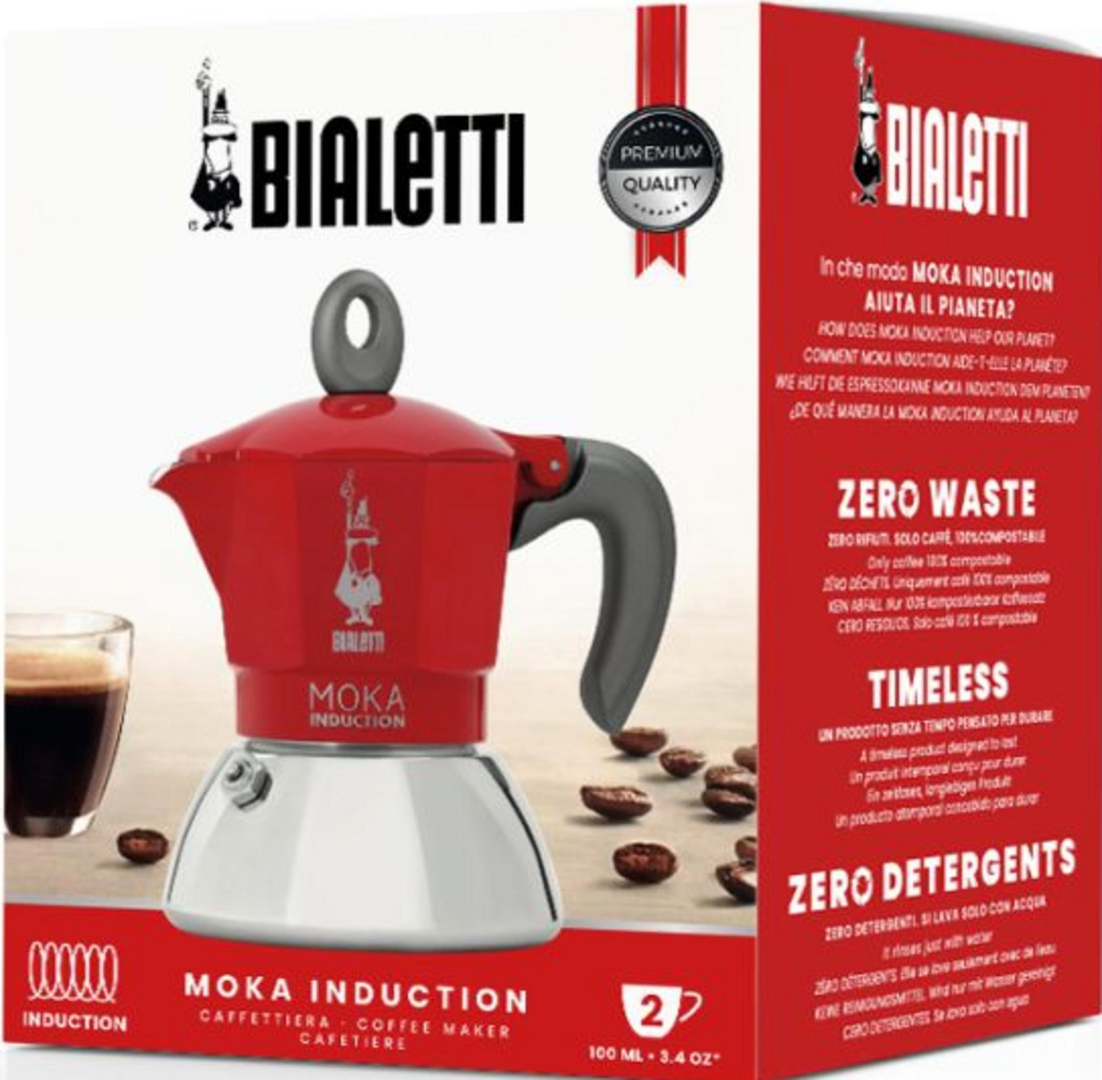 Czerwona kawiarka Bialetti Moka Induction ze szklanką, ziarnami kawy i opakowaniem.