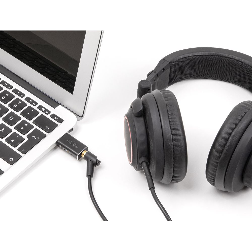 Un auricolare nero accanto a un laptop con un adattatore collegato alla porta USB-C.