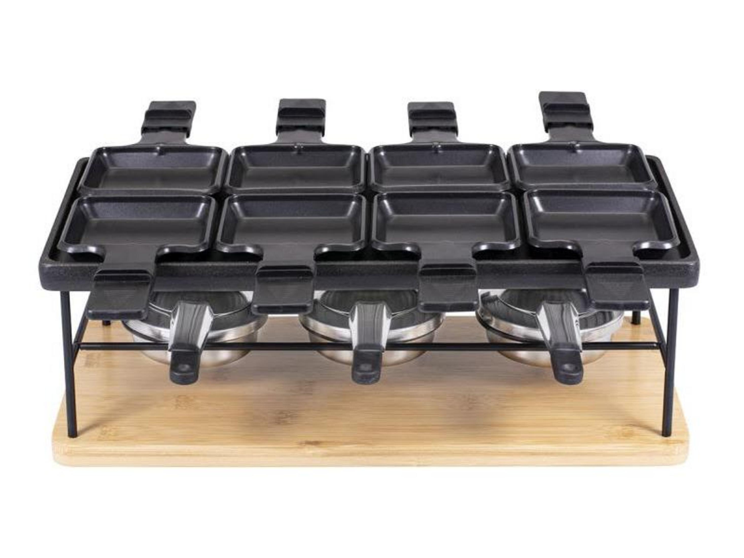 Una griglia per raclette con otto padelle su un tagliere di legno.