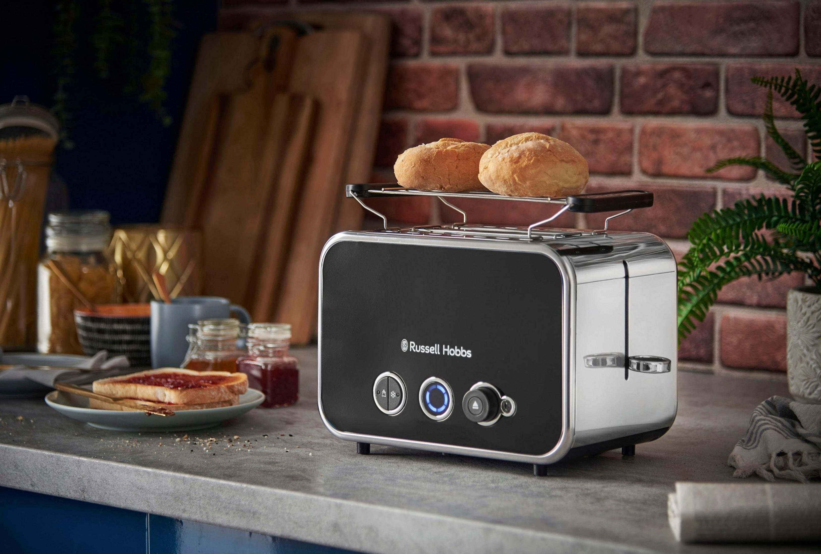 Un grille-pain noir avec des pains dessus, à côté de toasts à la confiture.