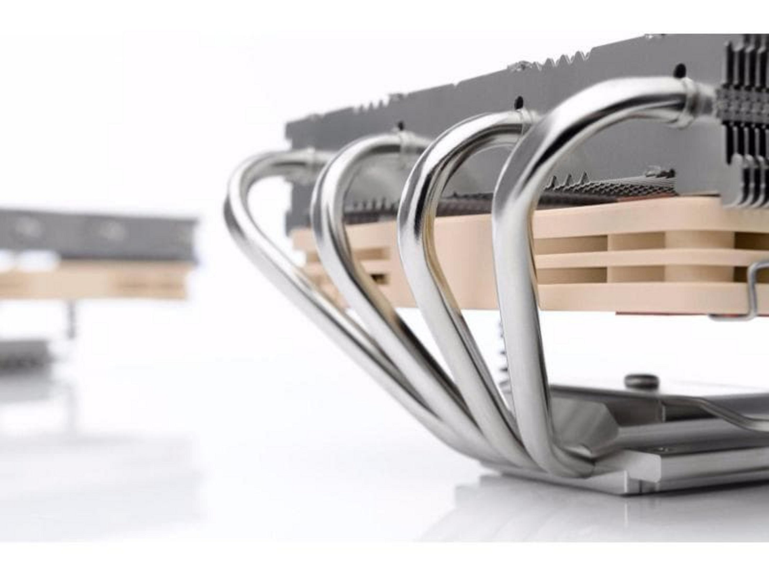 Zbliżenie srebrnego chłodzenia procesora z miedzianymi rurkami na białym tle.