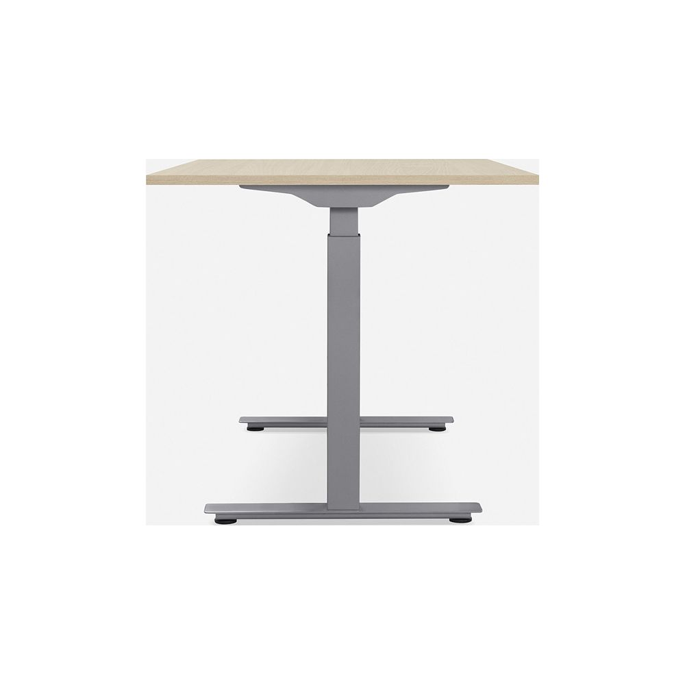 Ein höhenverstellbarer Schreibtisch mit heller Holzplatte und grauer Metallbasis.