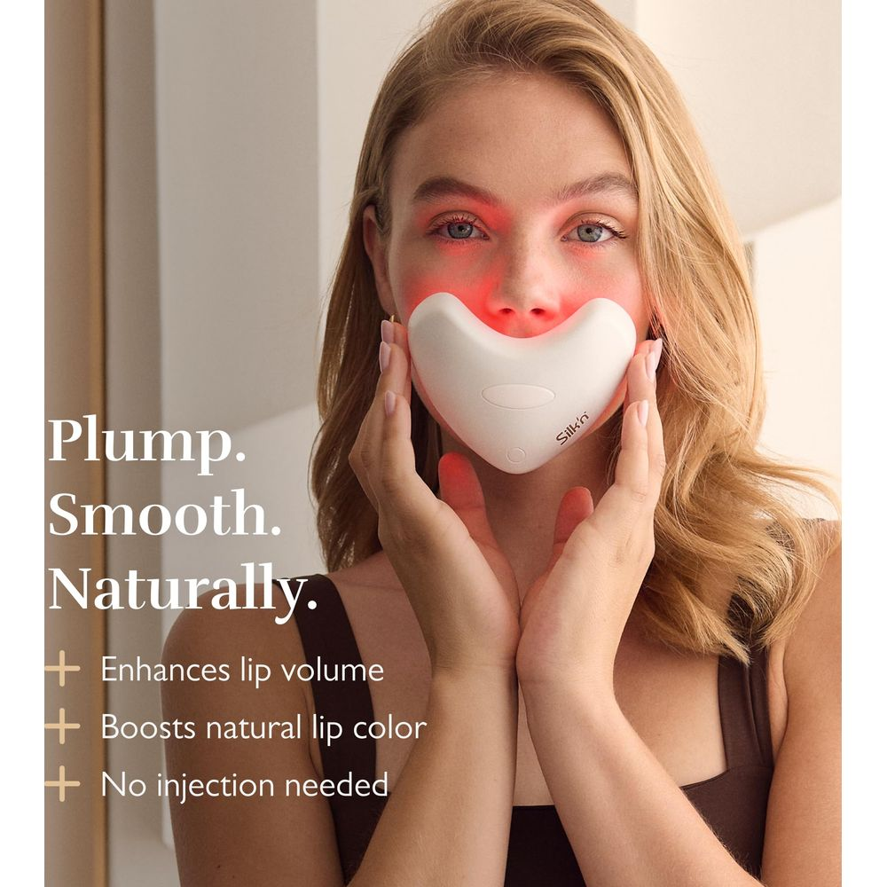 Una donna usa un dispositivo bianco a forma di cuore con luce rossa sulle labbra.