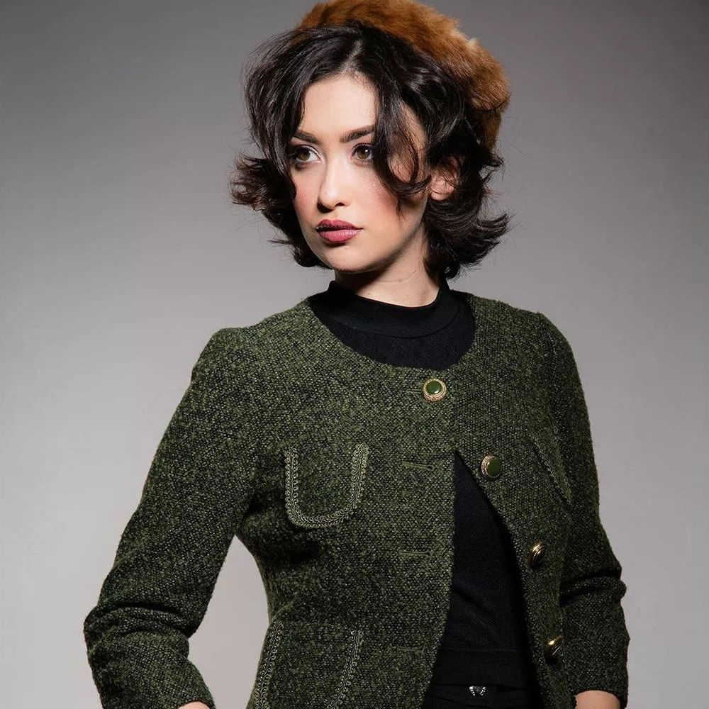 Femme avec un chapeau de fourrure marron et une veste en tweed vert, portrait.