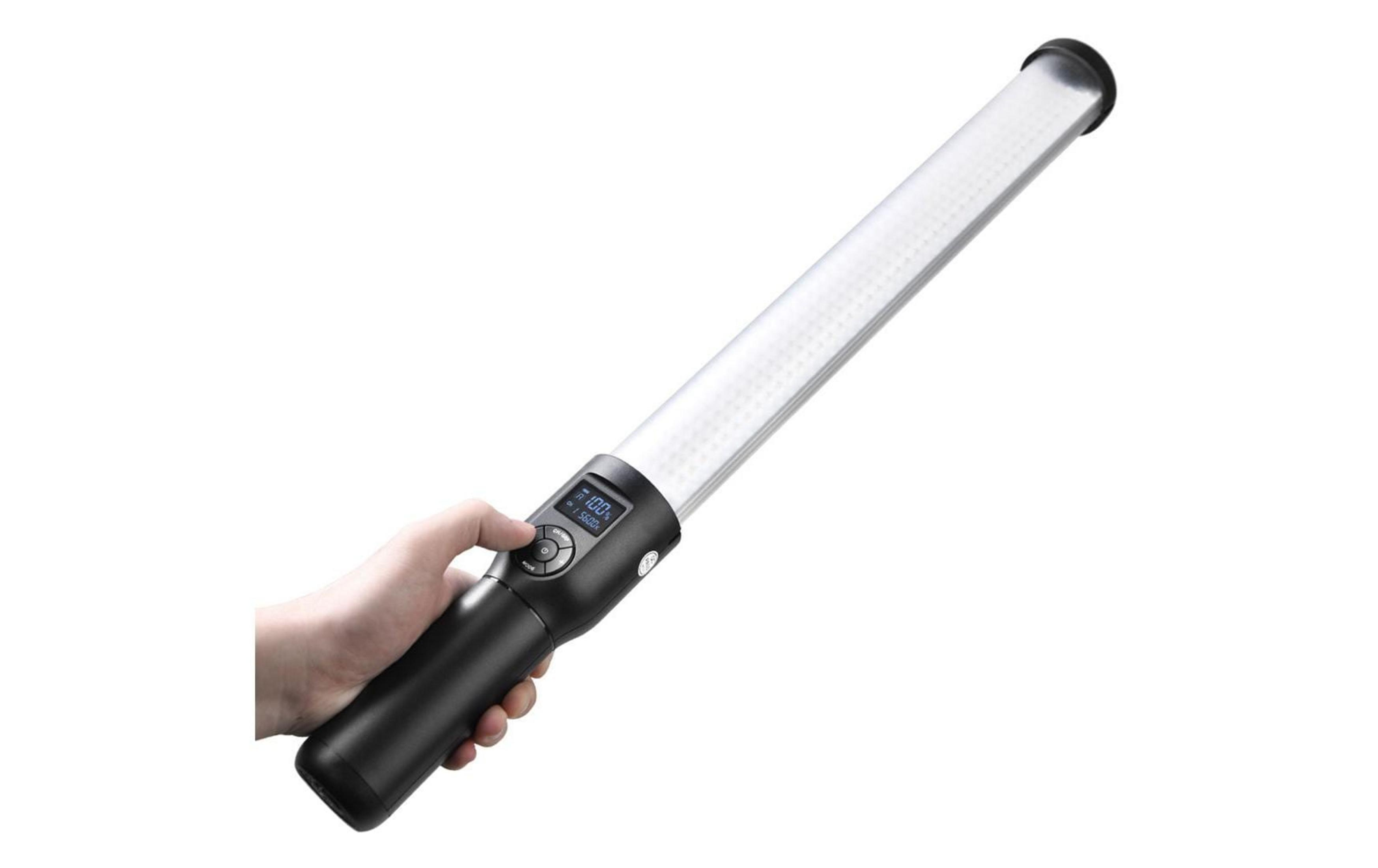 Main actionnant une baguette lumineuse noire avec écran LCD affichant 100% luminosité, 5600K.