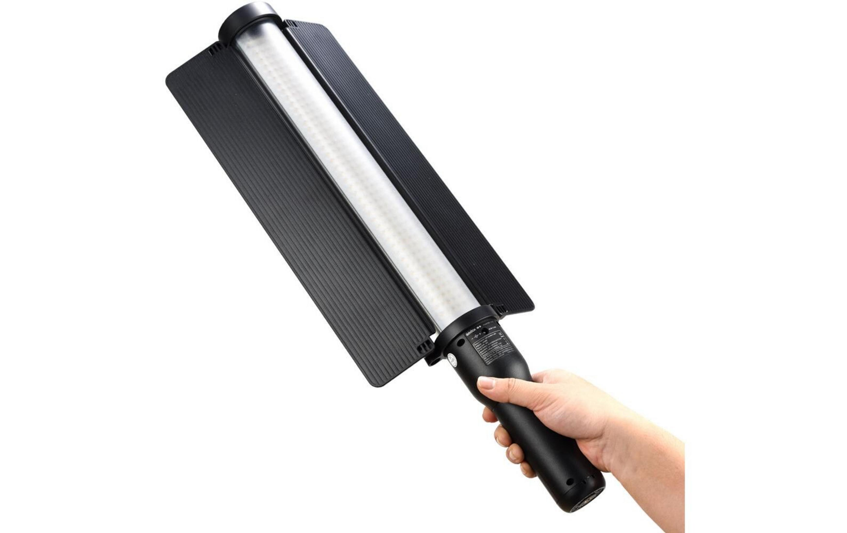 Une main tient une lumière LED noire avec des côtés noirs côtelés et une bande lumineuse vive.