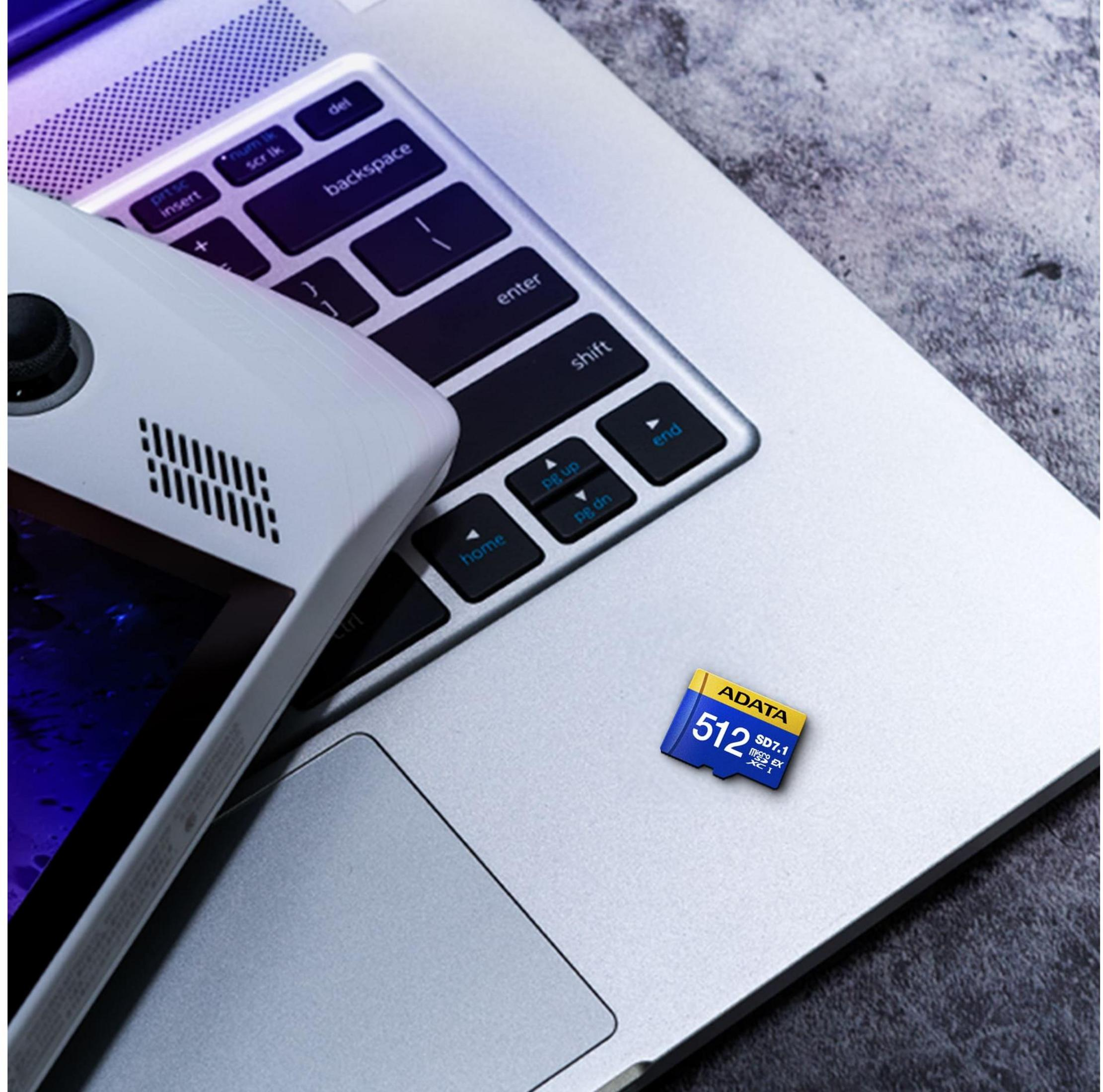 Ein weißes Gerät liegt auf einer Laptop-Tastatur neben einer MicroSD-Karte.