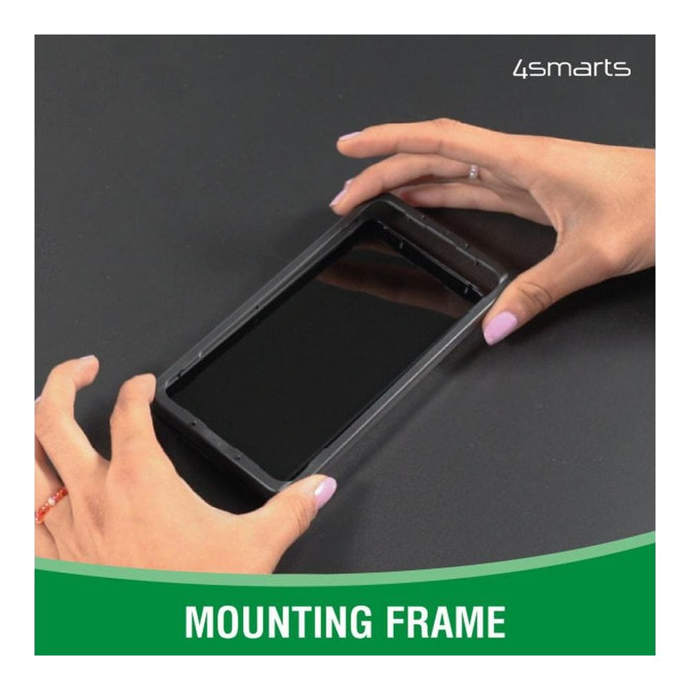 Mani montano una cornice nera per telefono su un tavolo nero.
