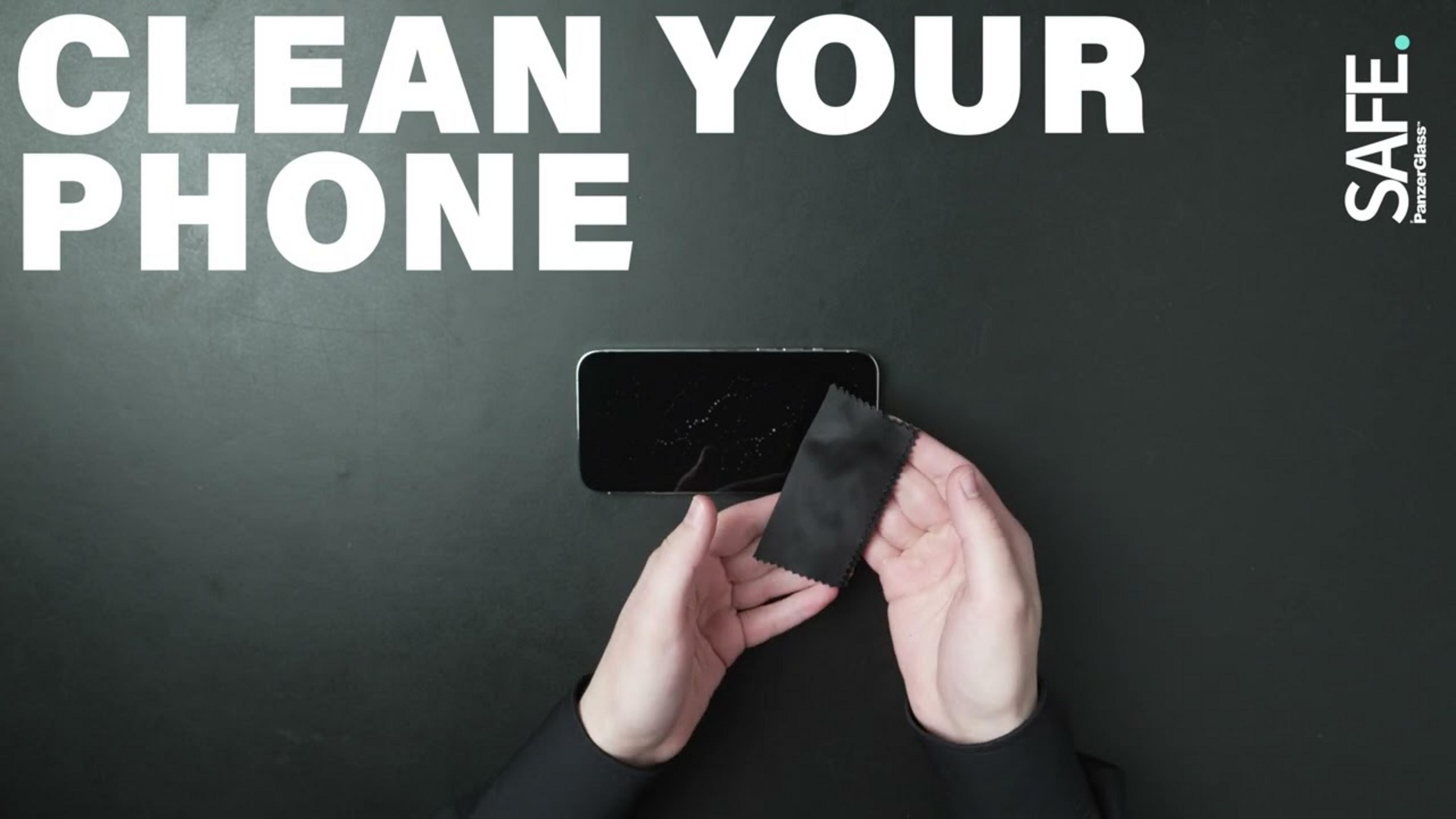 Mani tengono un panno in microfibra nero su uno smartphone su sfondo nero.