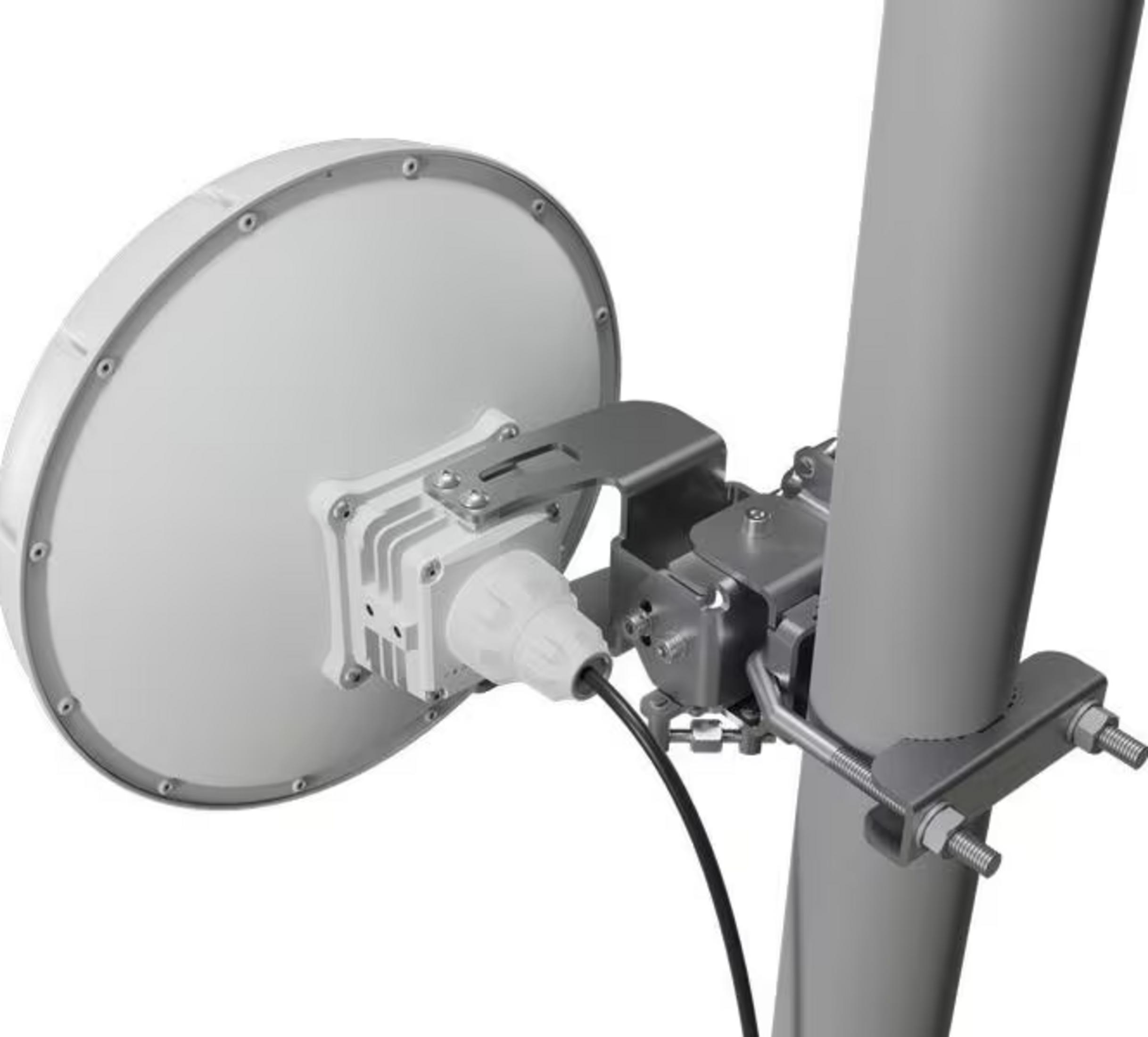 Un'antenna parabolica bianca è montata su un palo grigio.