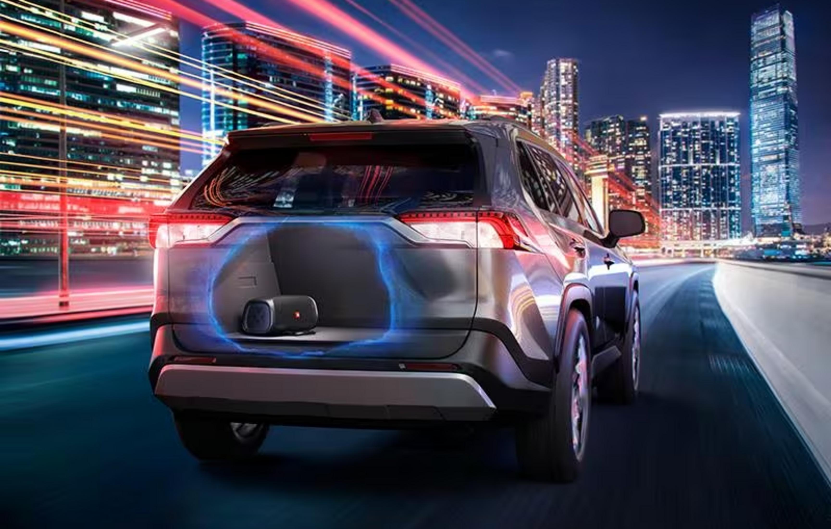 Ein schwarzer SUV fährt nachts durch eine Stadt mit Lichtern.