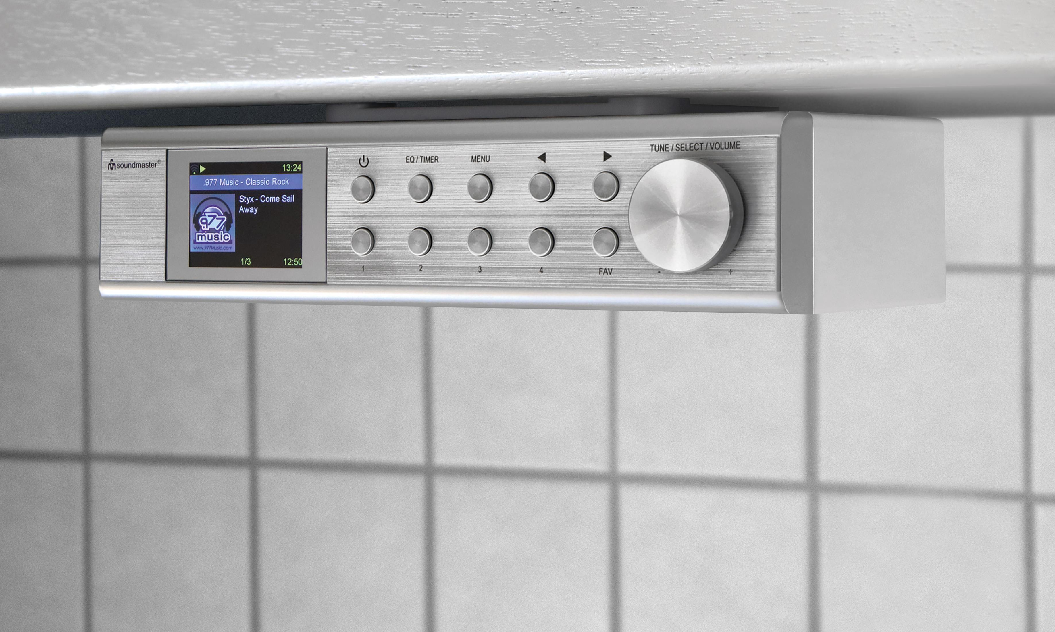 Ein silbernes Küchenradio mit Display, das Musikinformationen anzeigt.
