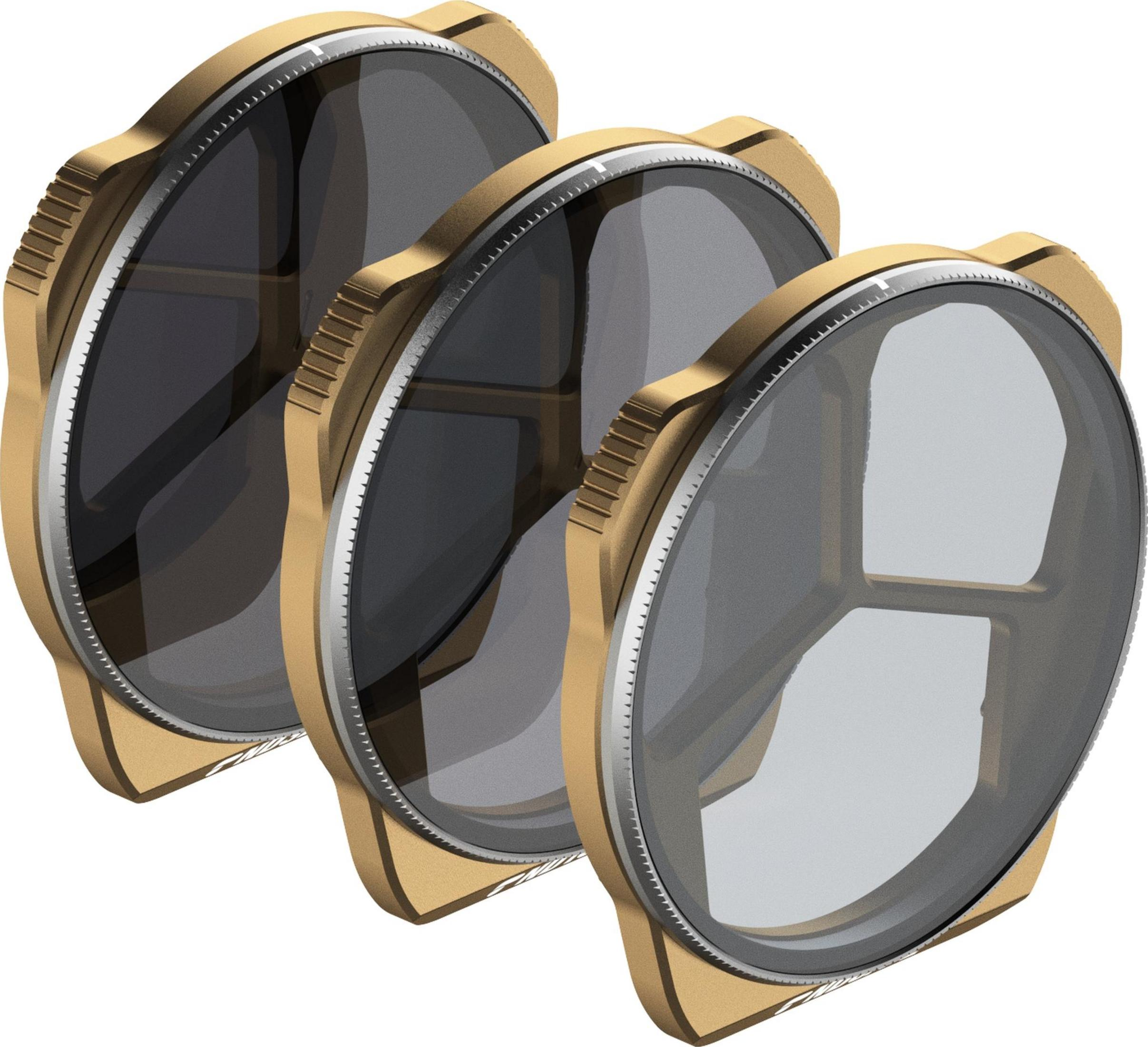 Trzy złote filtry do aparatu z srebrnymi pierścieniami i zębami, na białym tle.