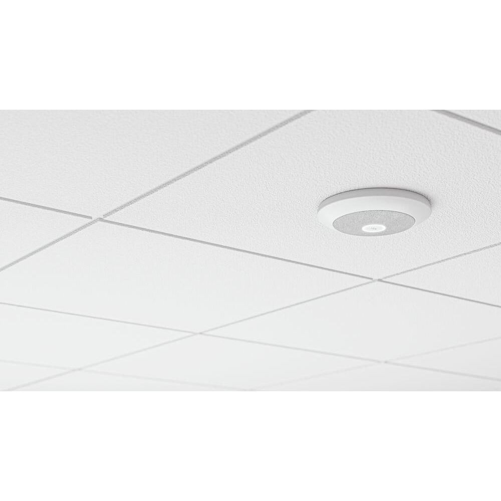 Szary głośnik jest zamontowany na białym suficie.