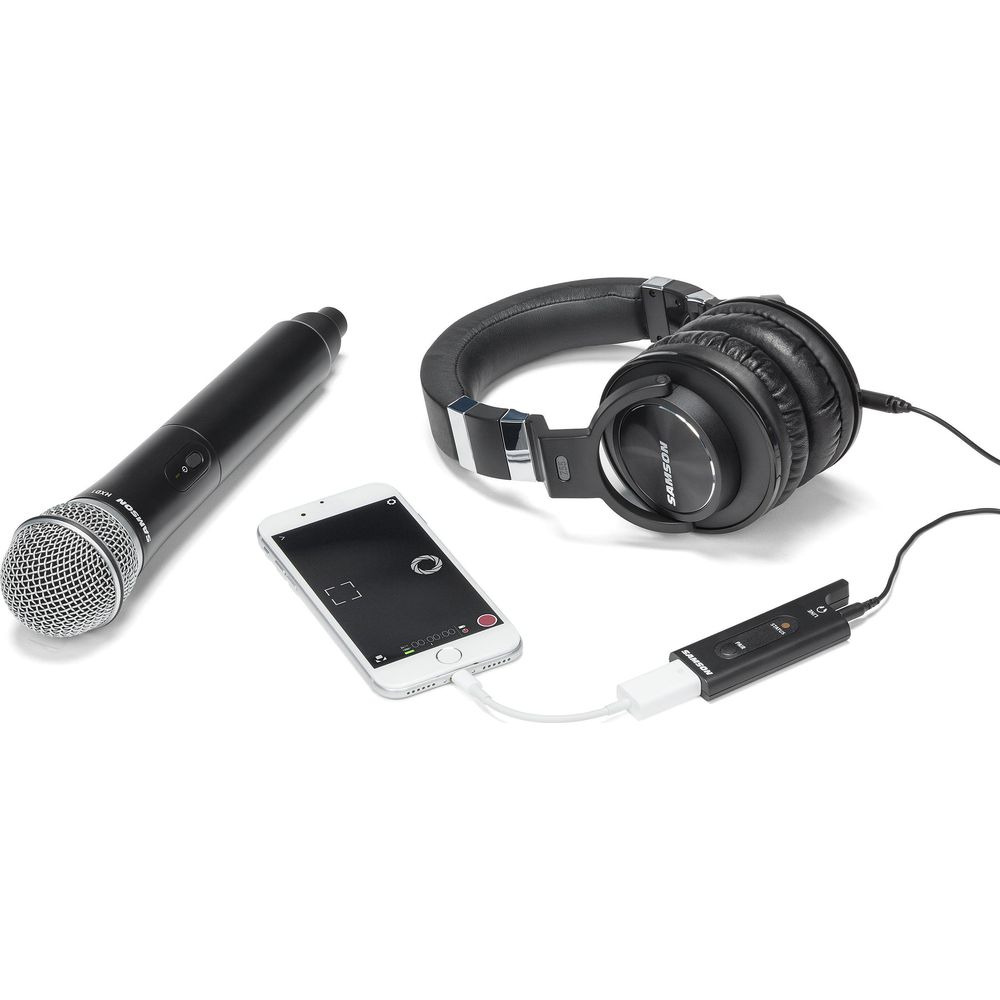 Microfono wireless, smartphone, cuffie e adattatore su sfondo bianco.