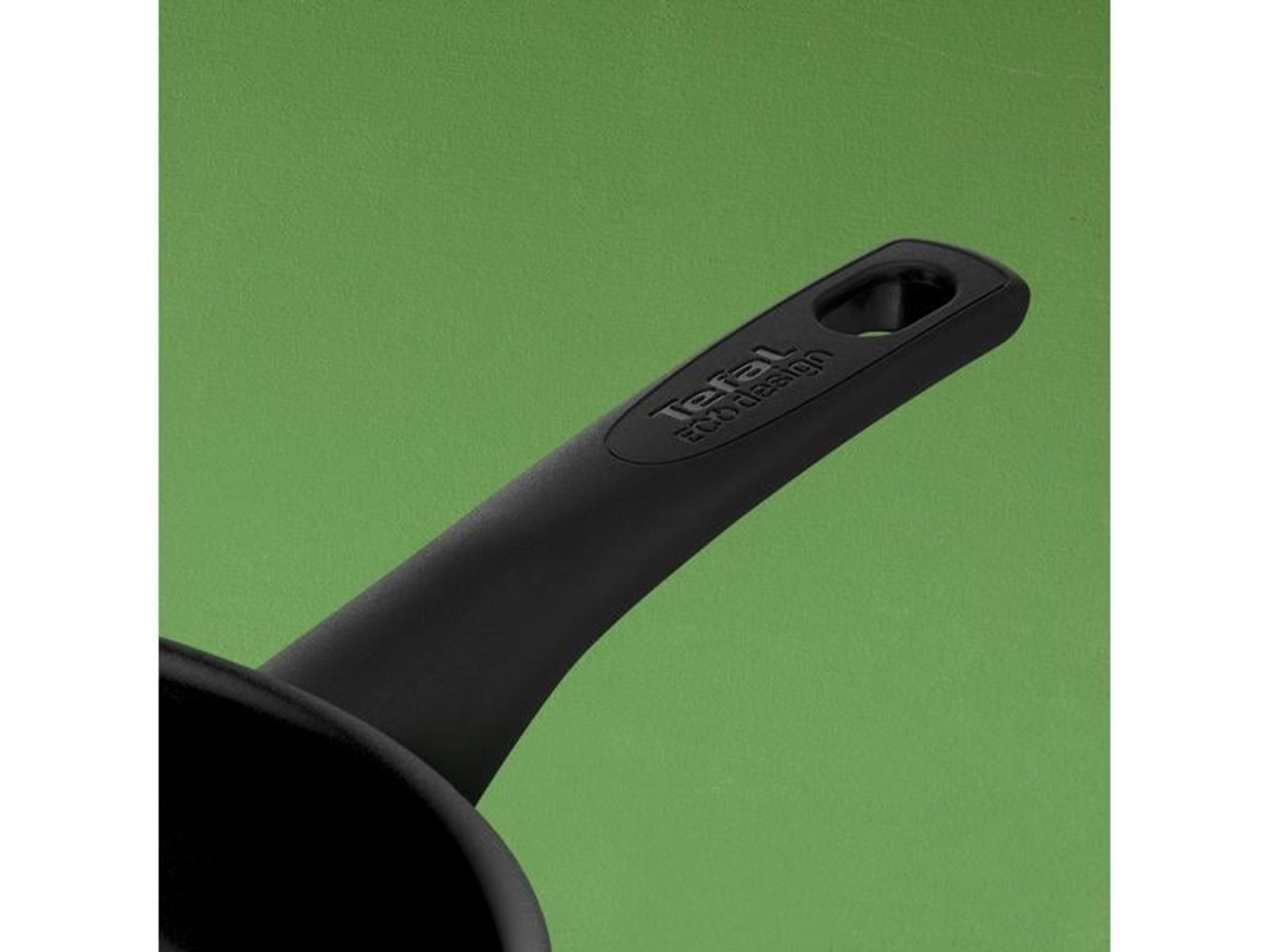 Czarna rączka z tekstem na zielonym tle.