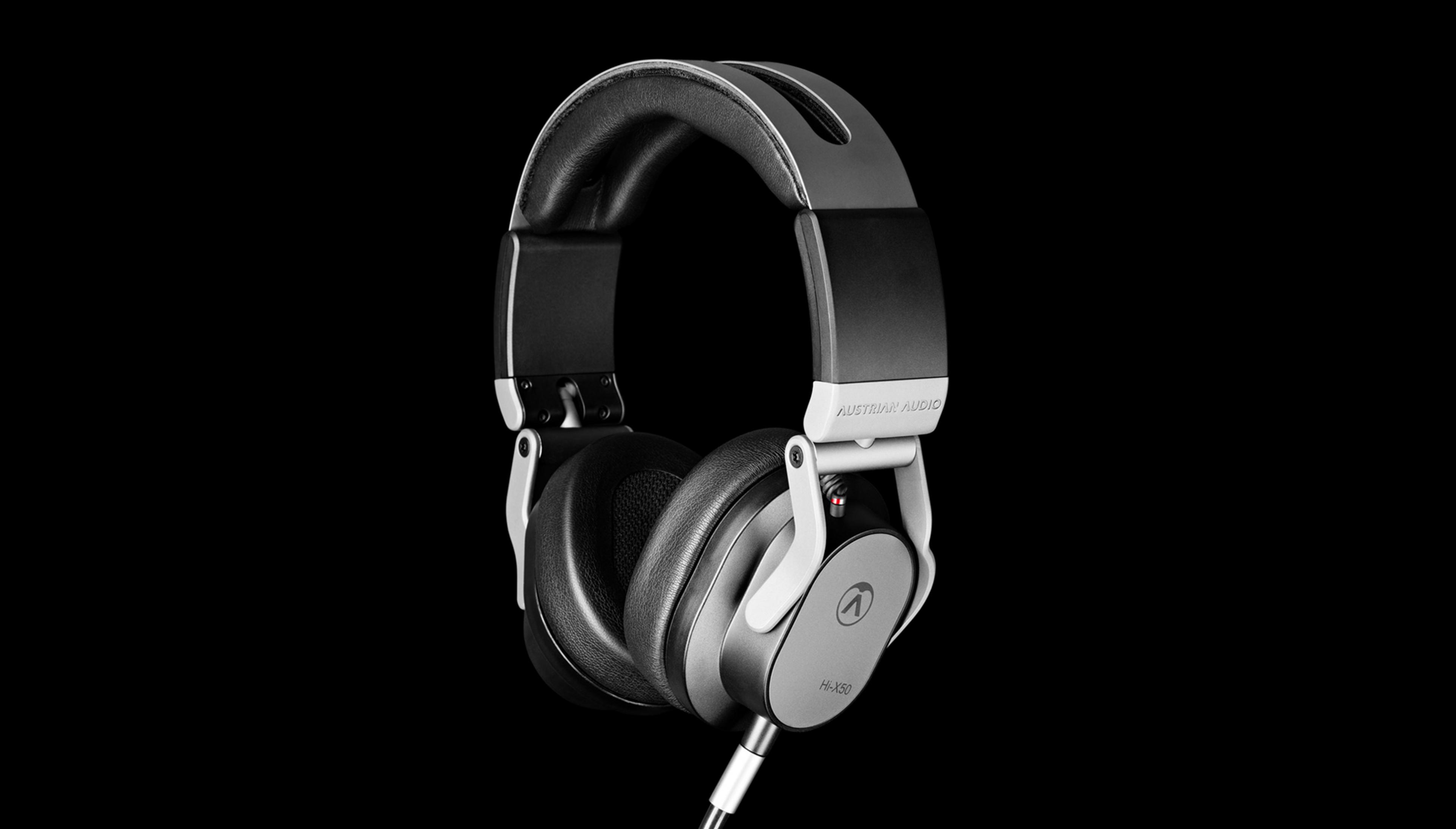 Casque gris avec arceau et oreillettes noirs sur fond noir.