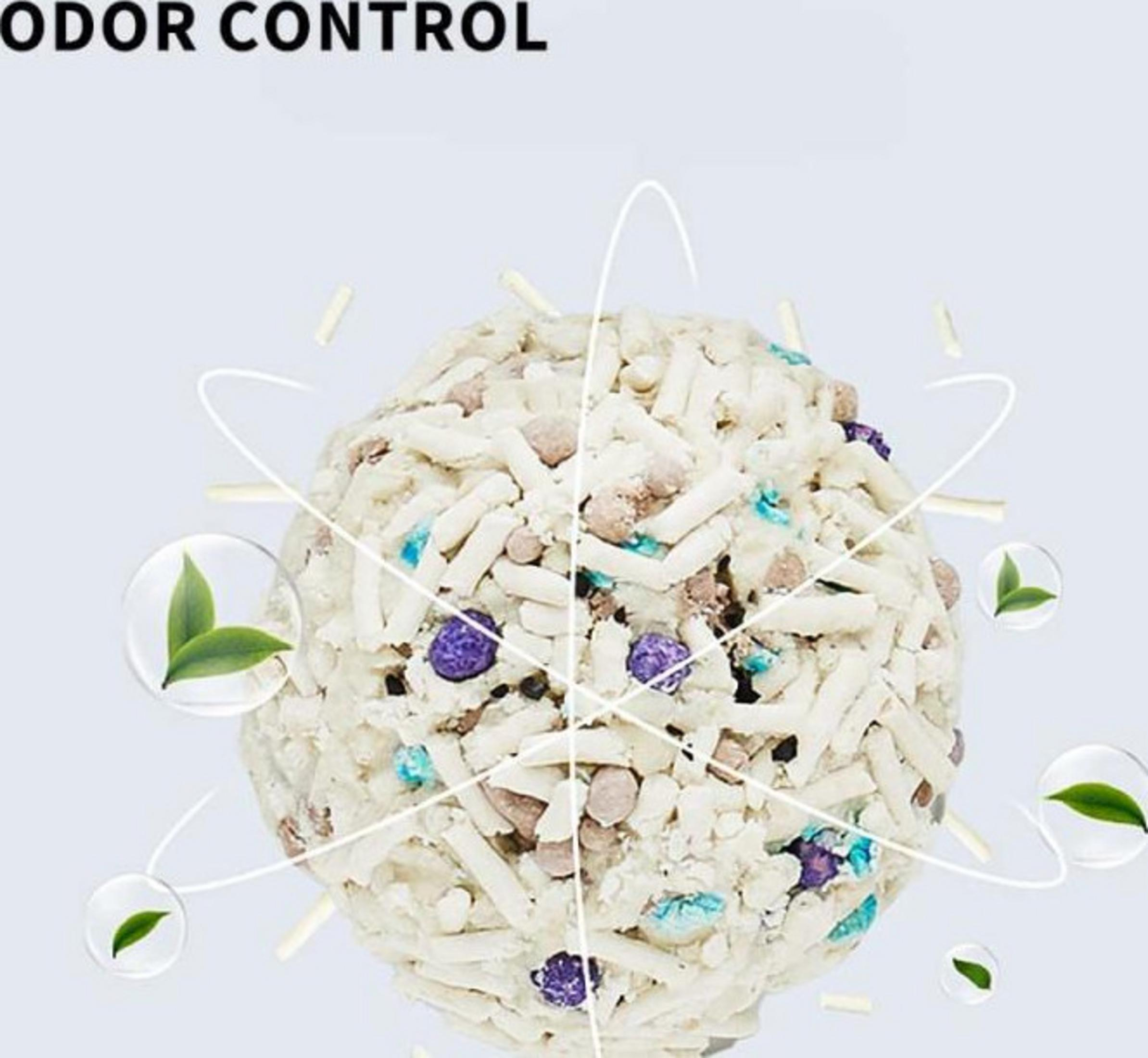 Kłębek żwirku dla kota z fioletowymi i niebieskimi koralikami, otoczony liśćmi.