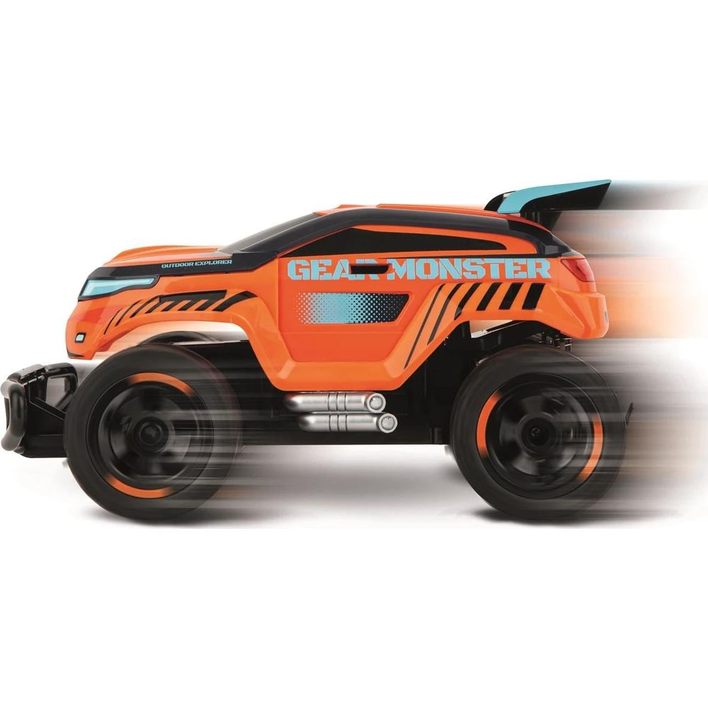 Un monster truck naranja a control remoto con detalles negros avanza rápido.
