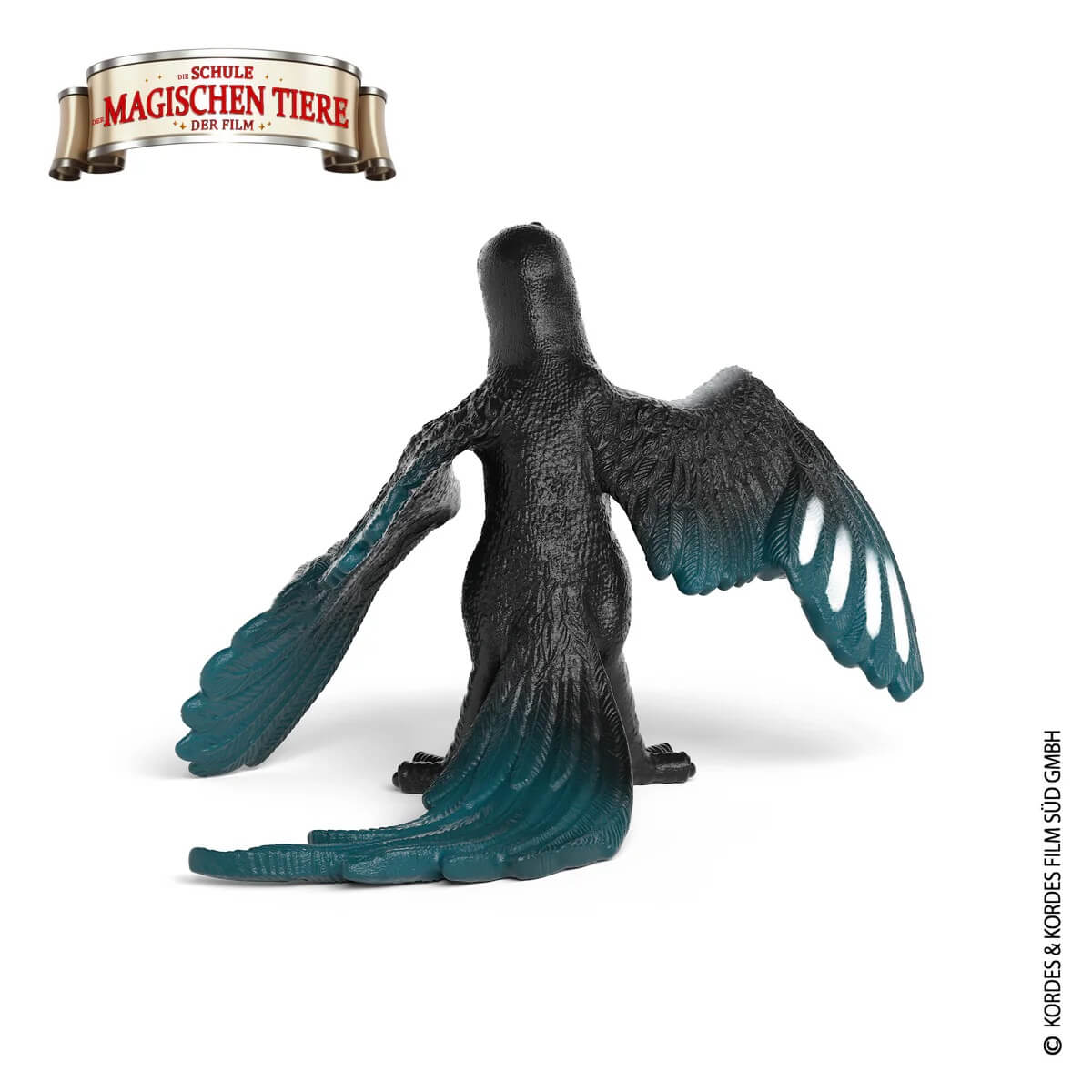Schwarze Vogelspielzeugfigur mit türkisfarbenen Flügelspitzen und Schwanzfedern.