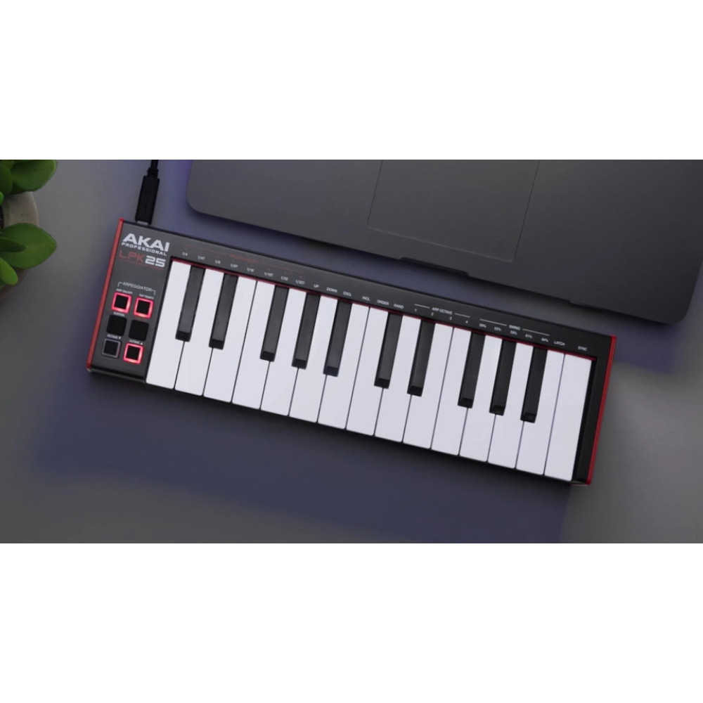 Czarny kontroler MIDI z czerwonymi akcentami obok laptopa.