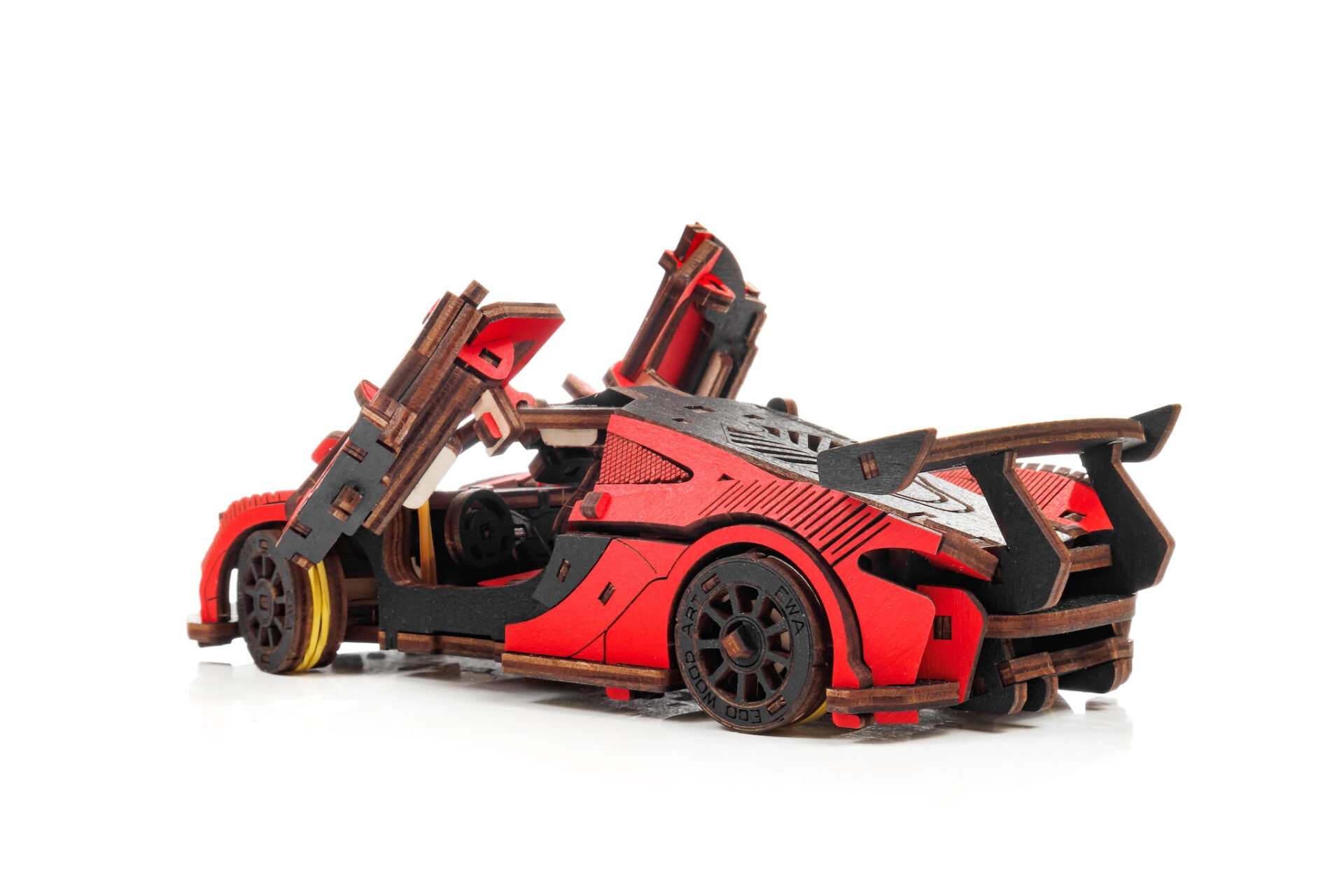 Une voiture modèle en bois rouge avec portes ouvertes et aileron arrière.