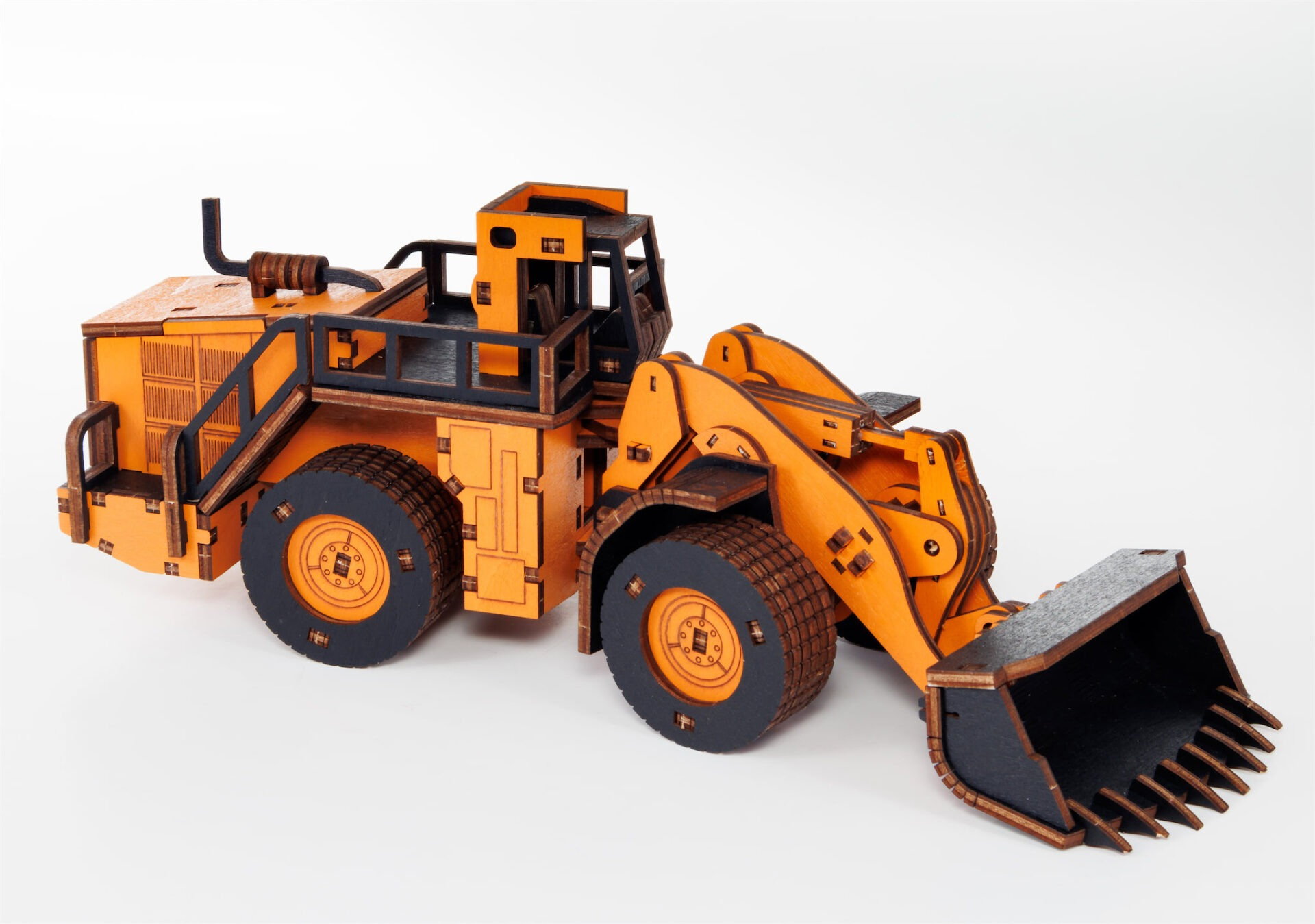 Orangefarbenes Holzradlader-Modell mit schwarzen Reifen und Schaufel auf weißem Hintergrund.