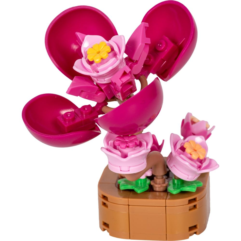 Un ensemble de construction de fleurs Lego roses avec des accents jaunes et des feuilles vertes.