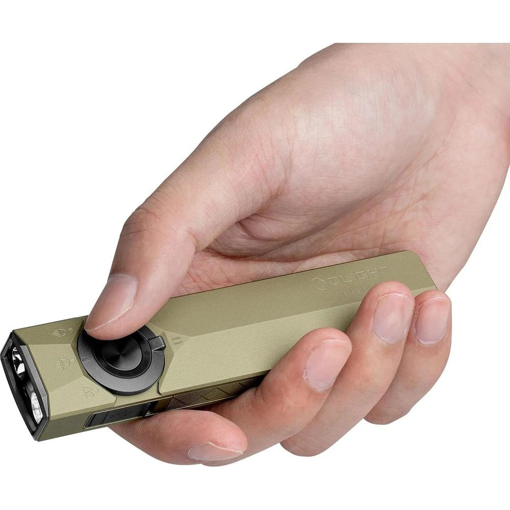 Une main tient une lampe de poche vert kaki avec bouton noir et symboles.