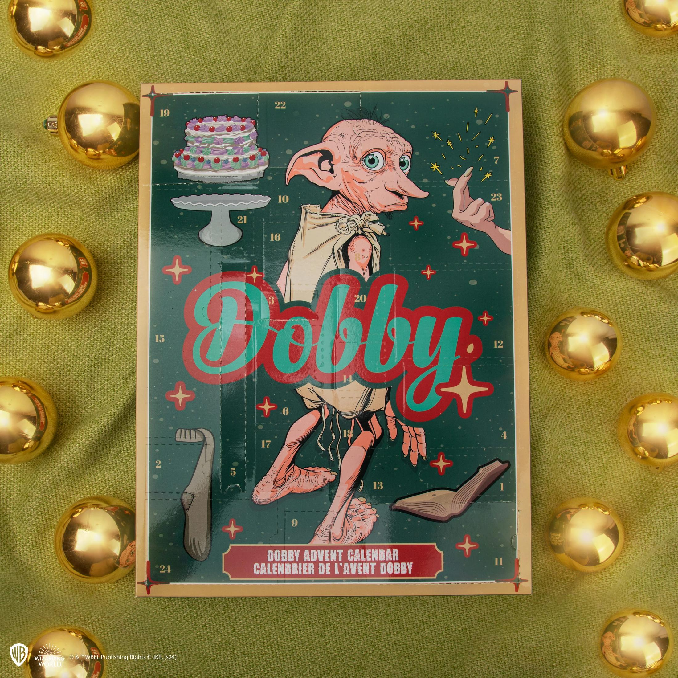 Un calendario dell'avvento di Dobby con illustrazione di Dobby, circondato da palline dorate su tessuto verde.