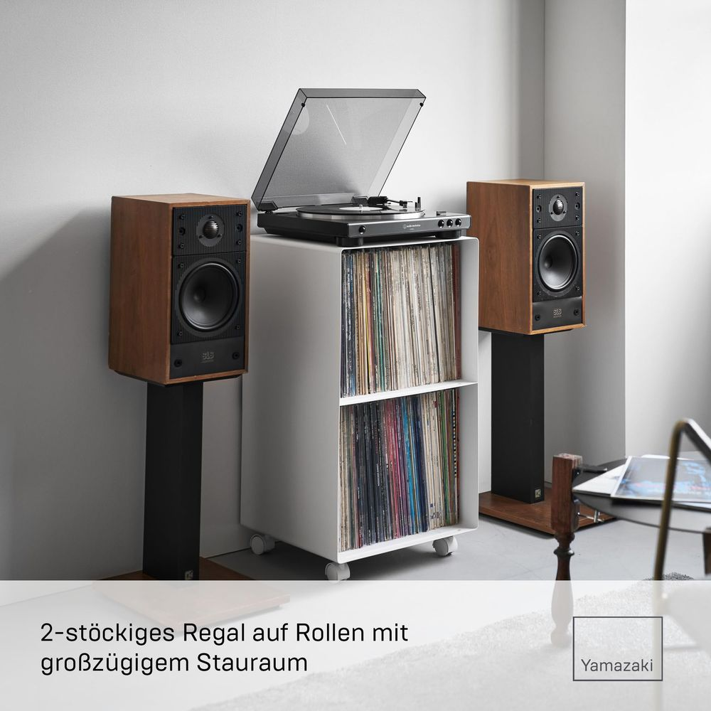 Zwei braune Lautsprecher mit Plattenspieler auf weißem Regal mit Rollen.